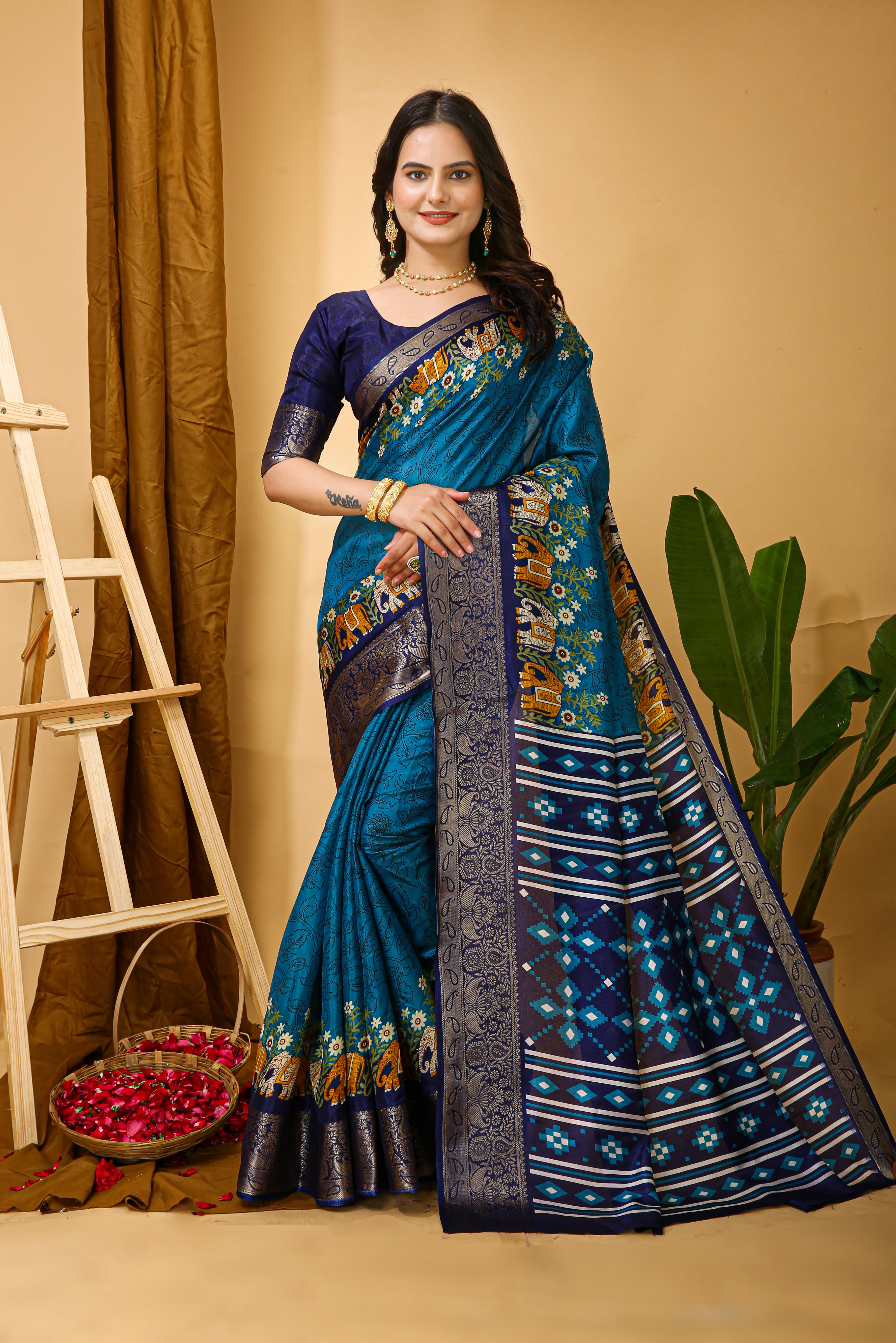 Woman wearing a blue saree with a floral pattern on a beige background