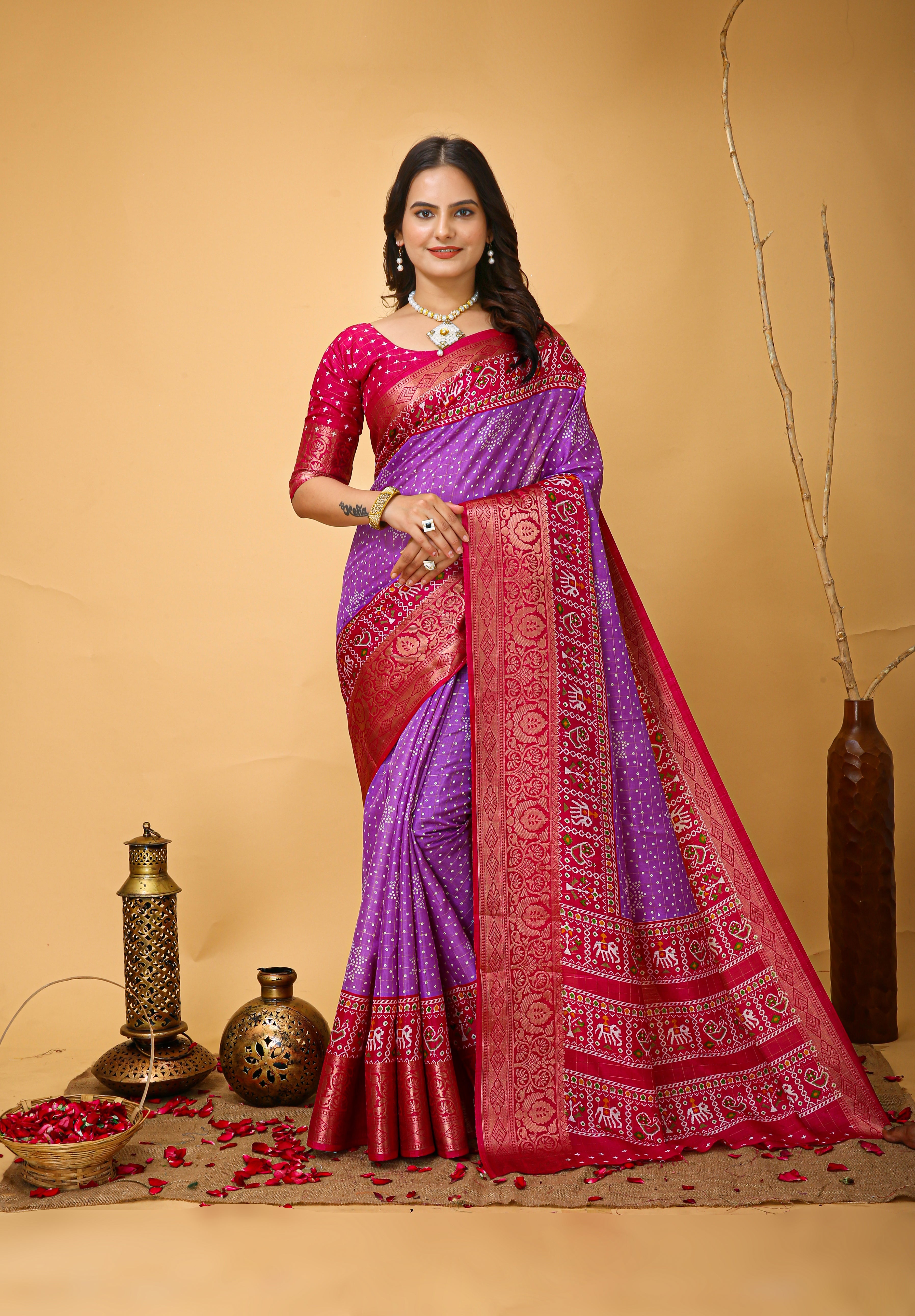 Woman wearing a traditional saree with a purple and red design on a beige background