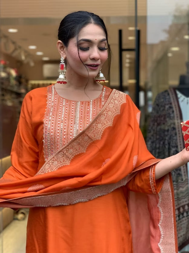 Woman wearing an orange traditional outfit with a saree in a store setting