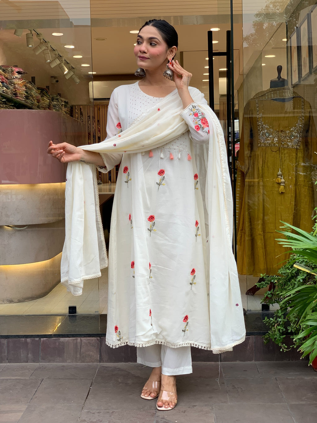 Woman in a white traditional kurta set outfit with floral embroidery in a store setting
