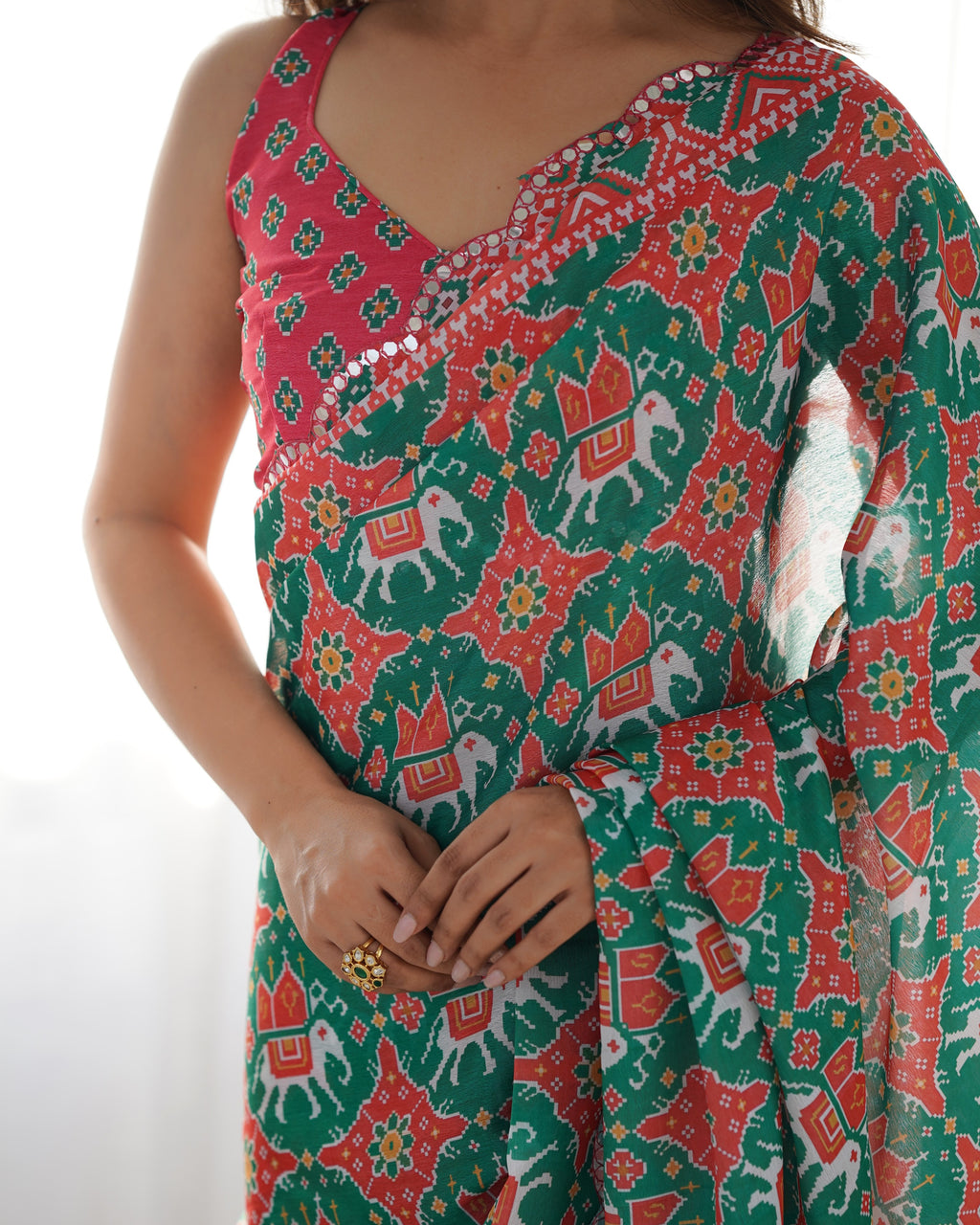 Woman wearing a colorful patterned saree with a white background