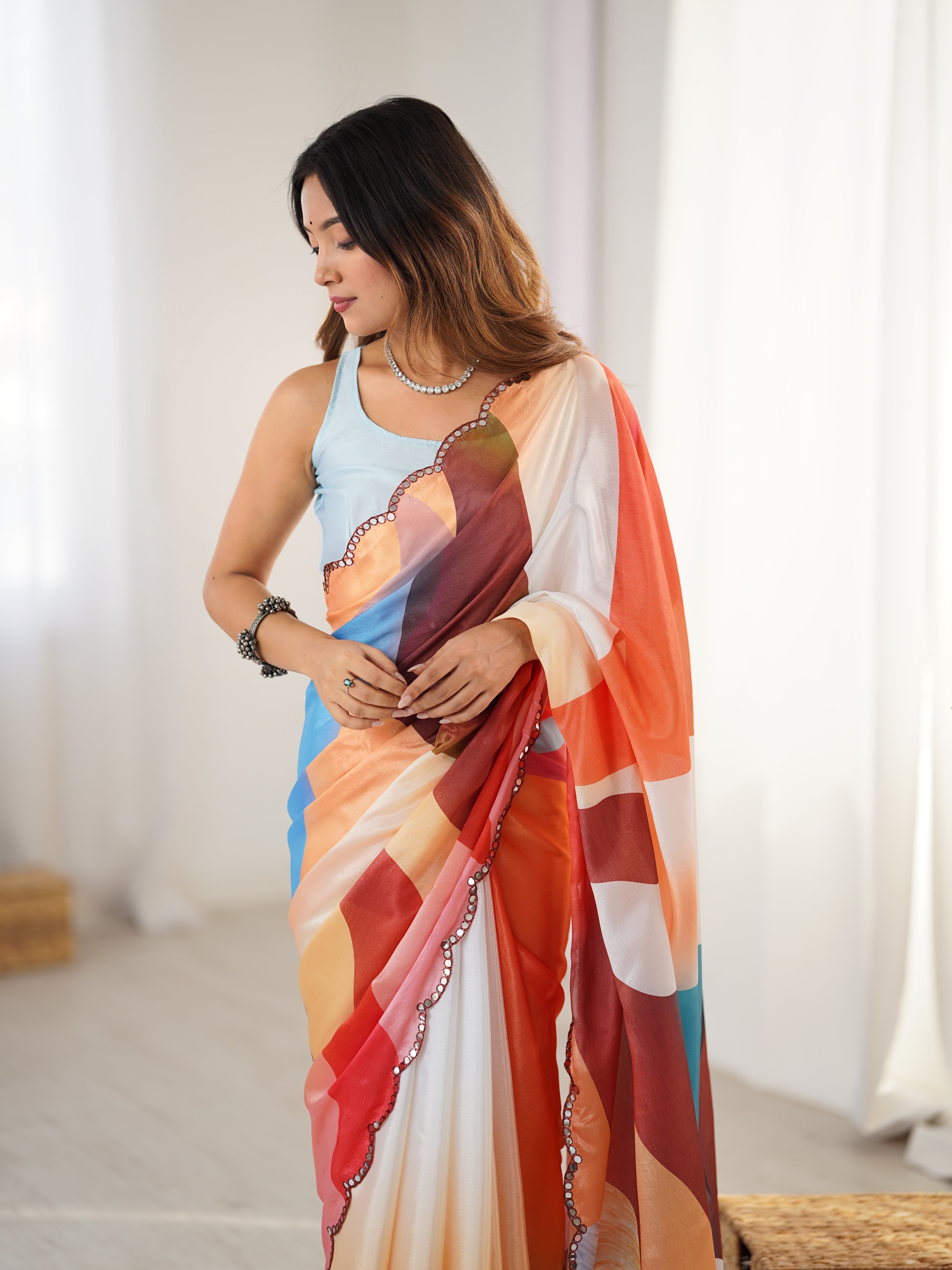 Woman wearing a colorful saree with a neutral background