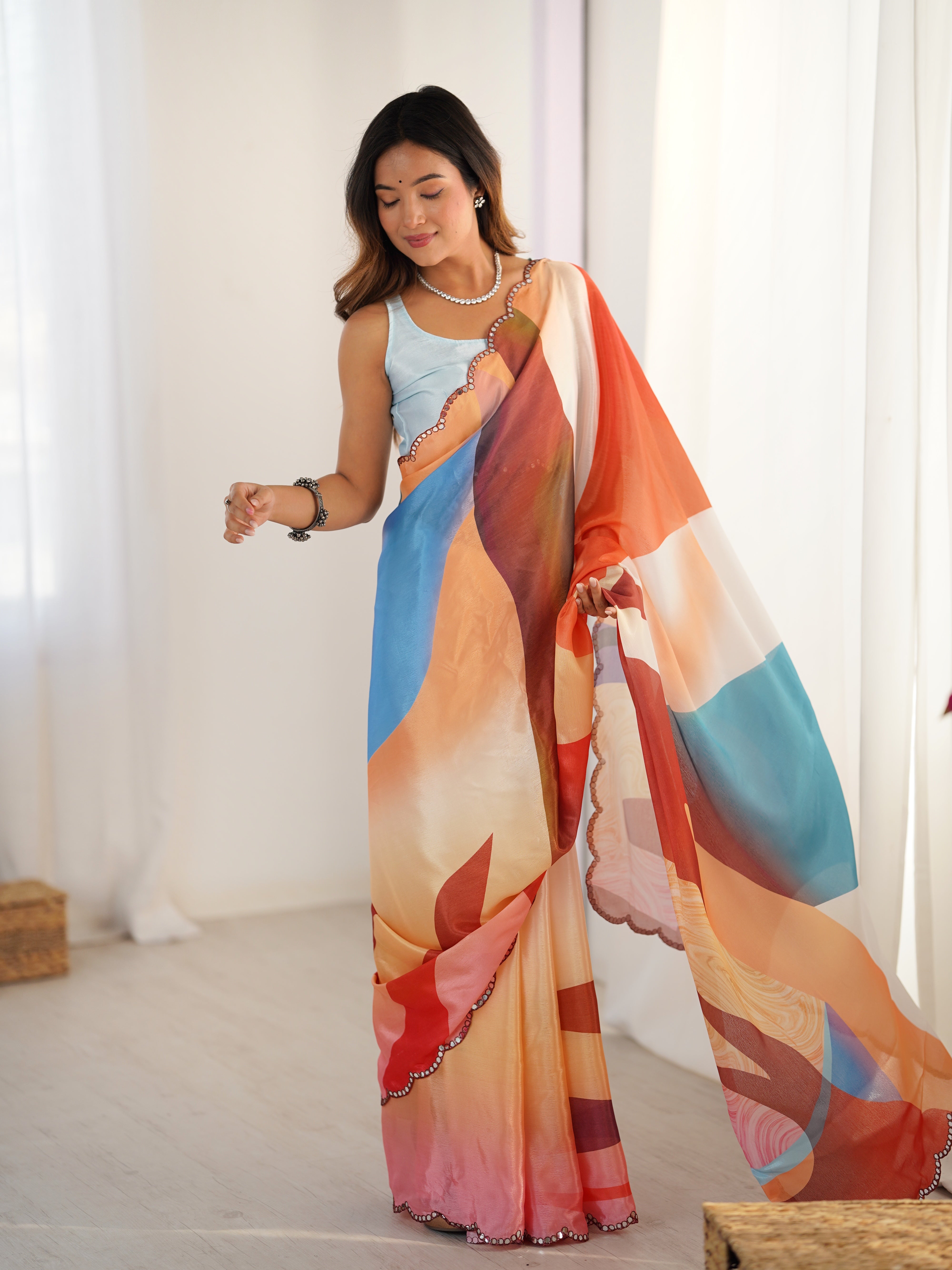 Woman holding a colorful scarf with abstract patterns in a bright room.