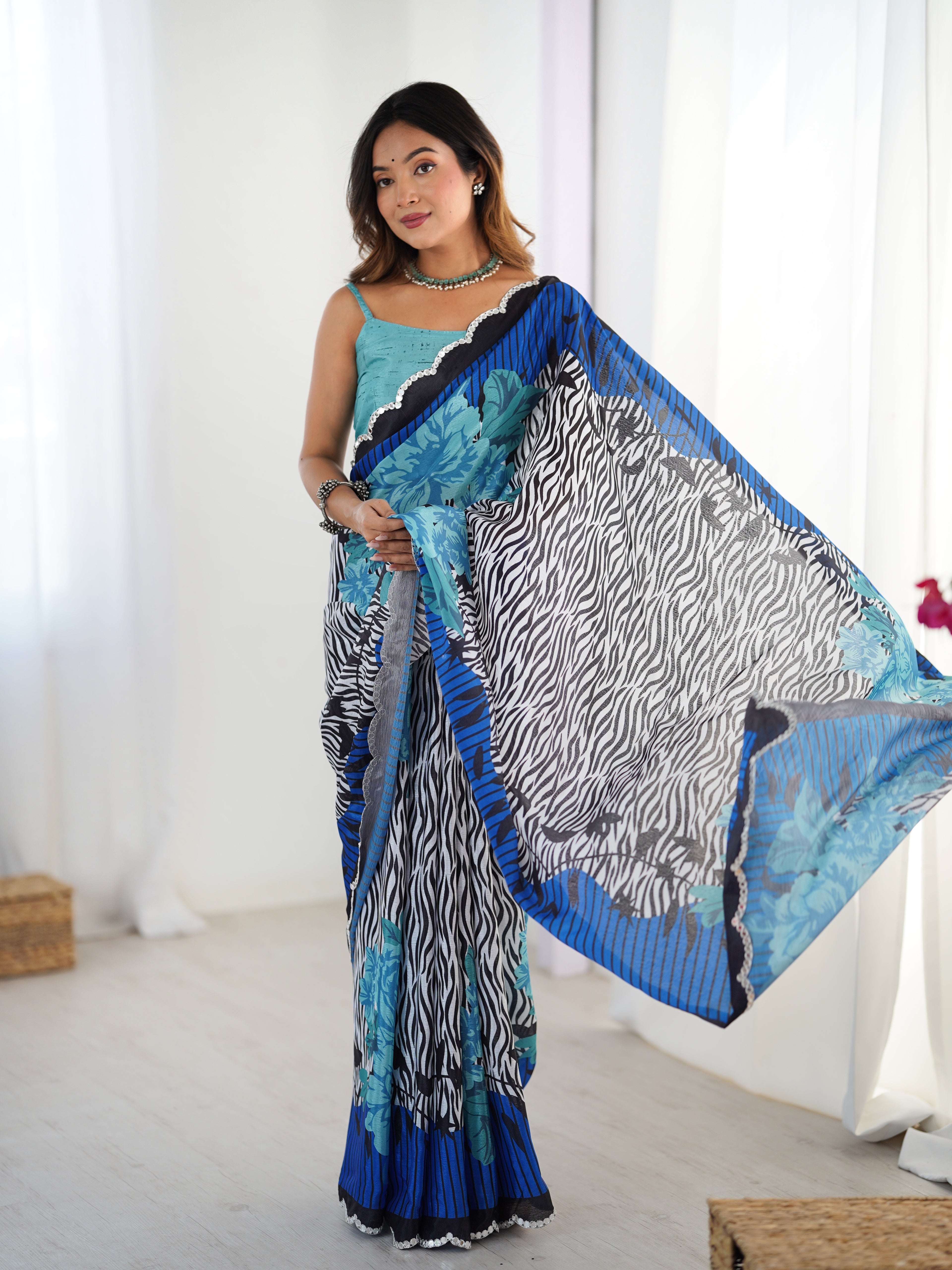 Woman wearing a colorful saree with a zebra pattern in a bright room.