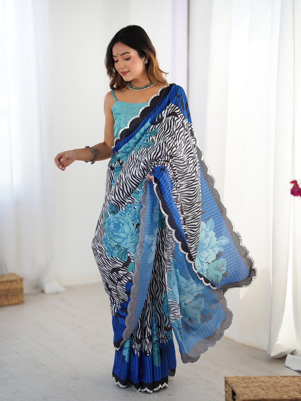 Woman wearing a colorful saree with a zebra pattern in a bright room.
