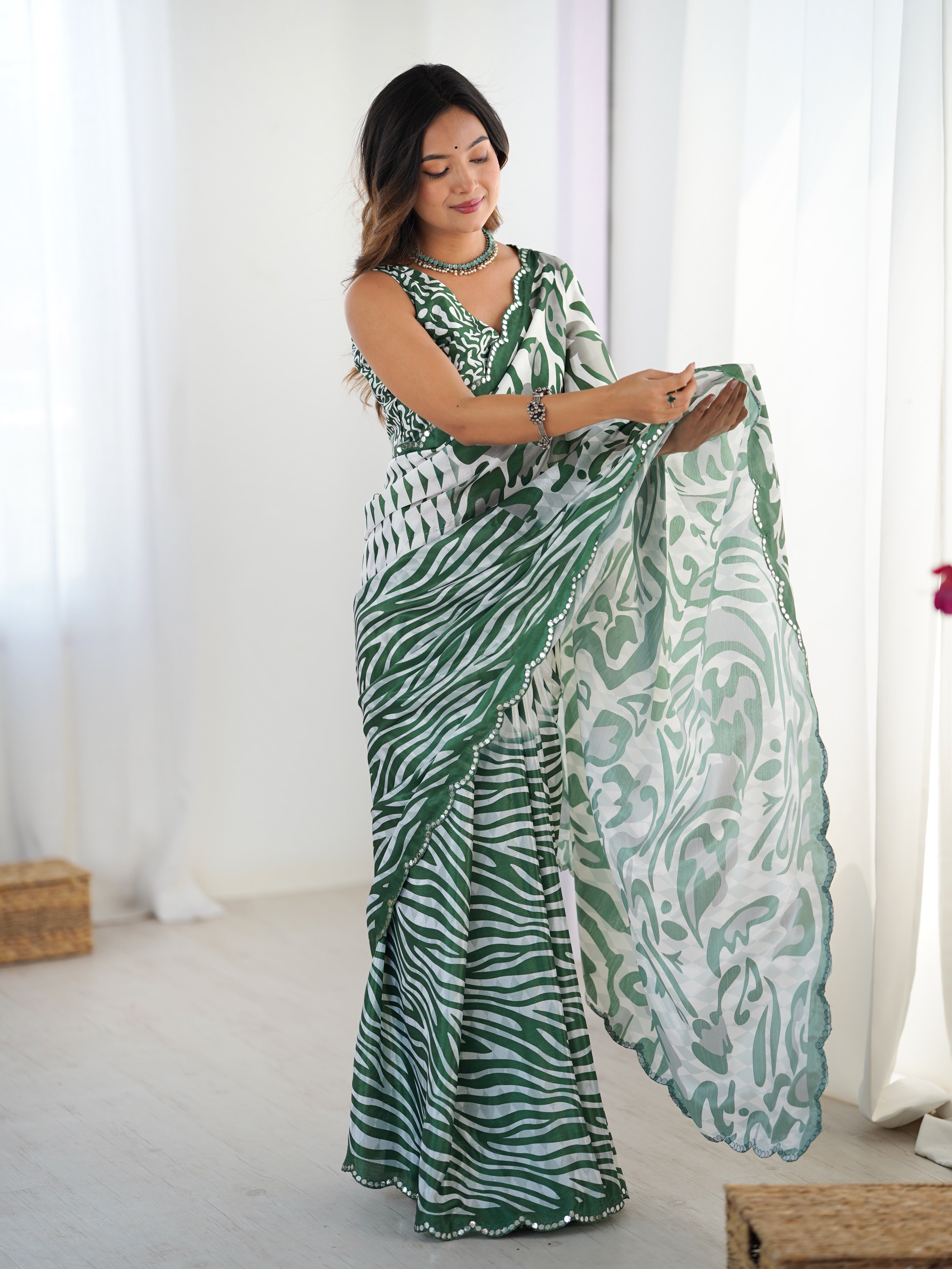 Woman holding a green and white patterned scarf in a bright room.