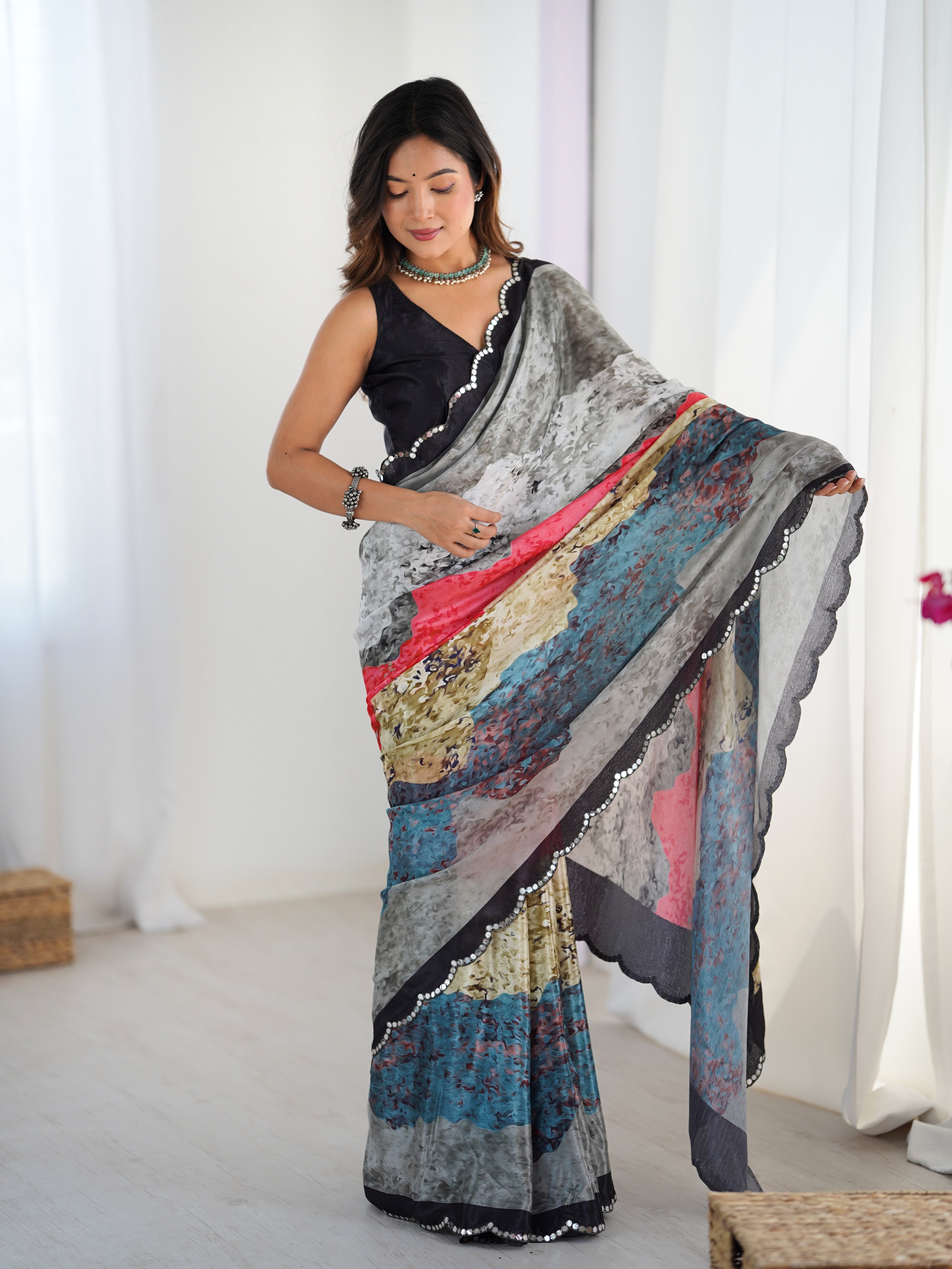 Woman wearing a colorful saree with a white curtain background