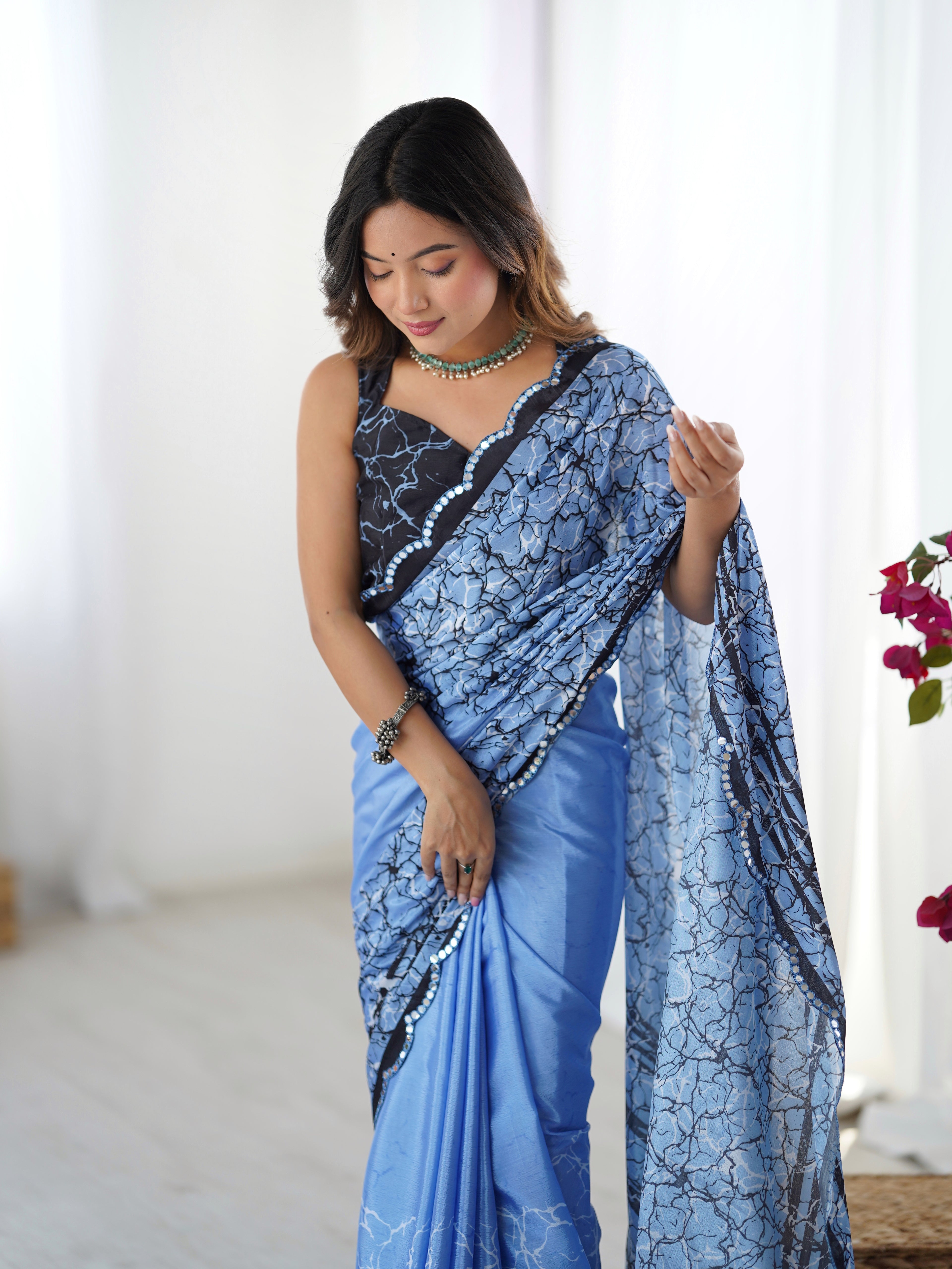 Woman wearing a sky blue saree with a white background