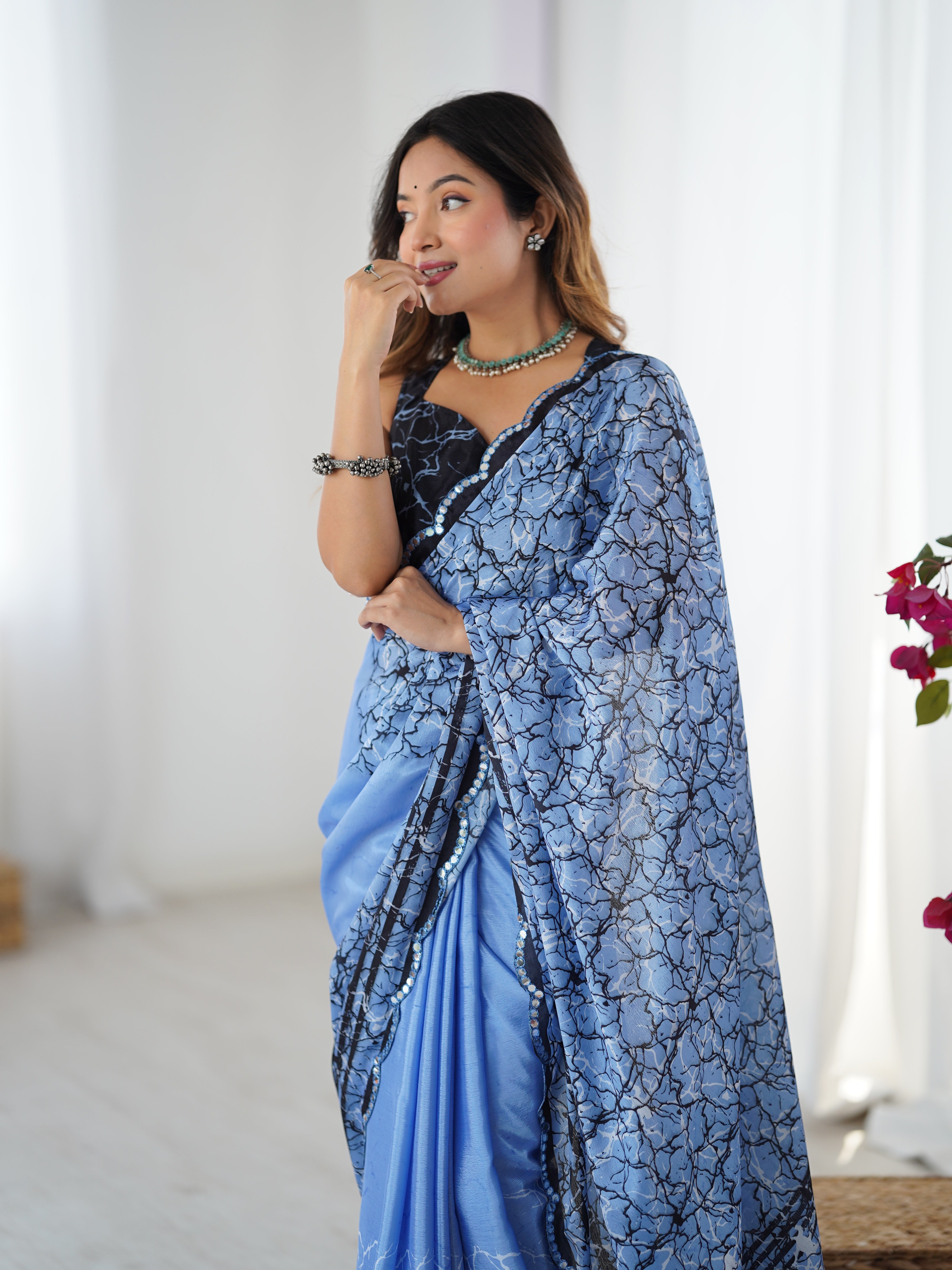 Woman wearing a sky blue saree with a white background