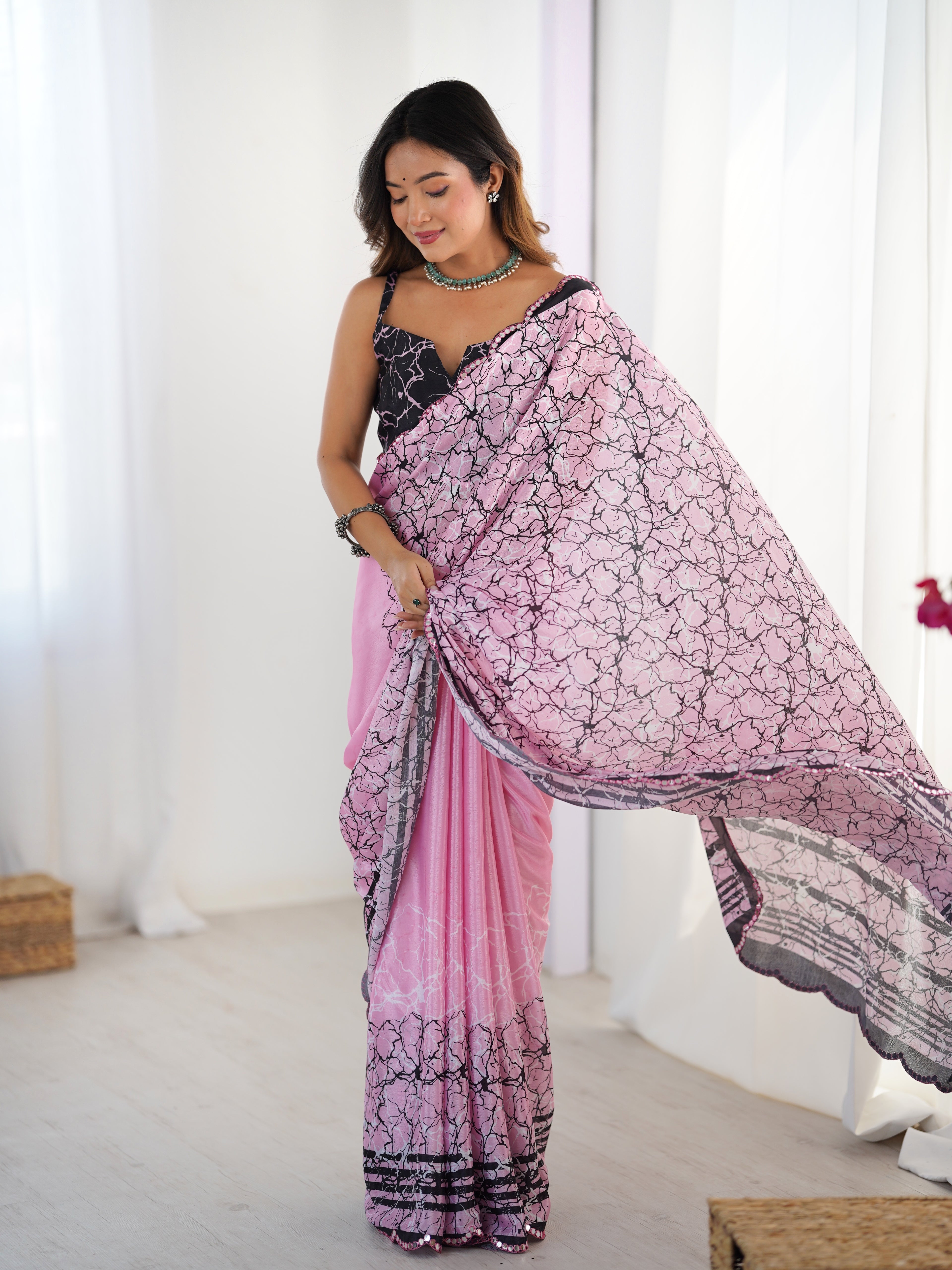Woman wearing a pink and black saree with a white background