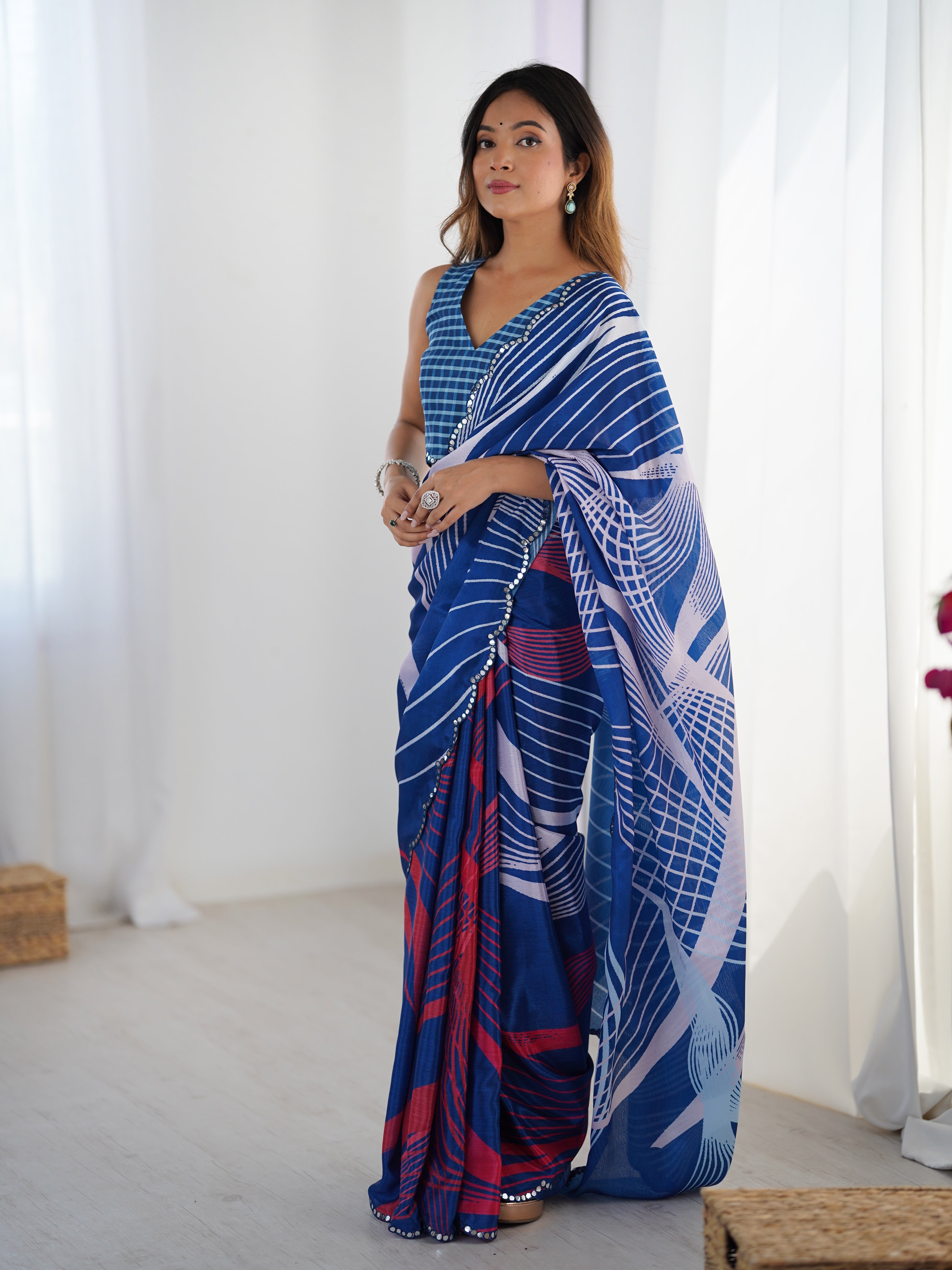 Woman wearing a blue patterned saree in a bright room