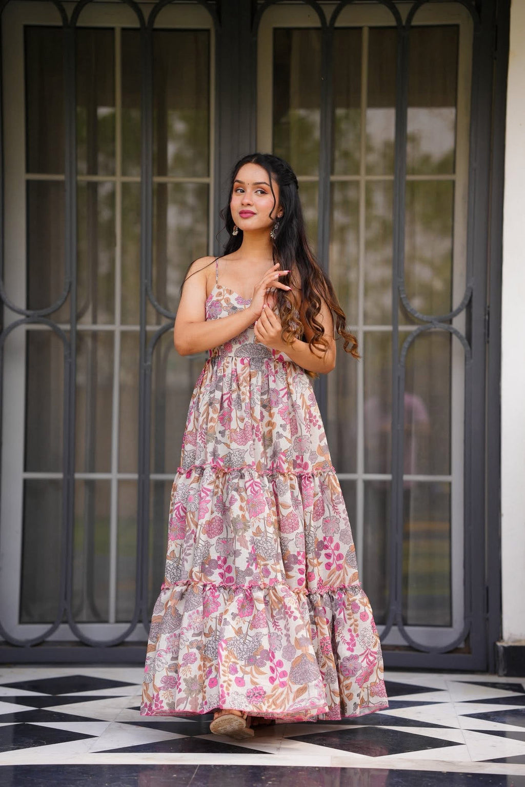 Woman in a poly rayon dress standing in front of a glass door with a checkered floor.