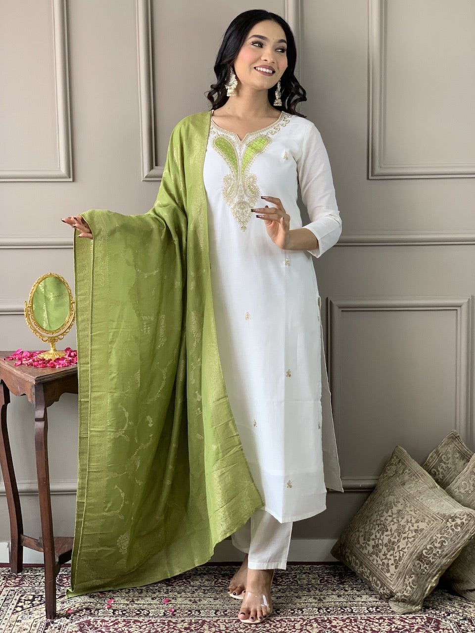 Woman wearing a white kurta with green dupatta in an indoor setting