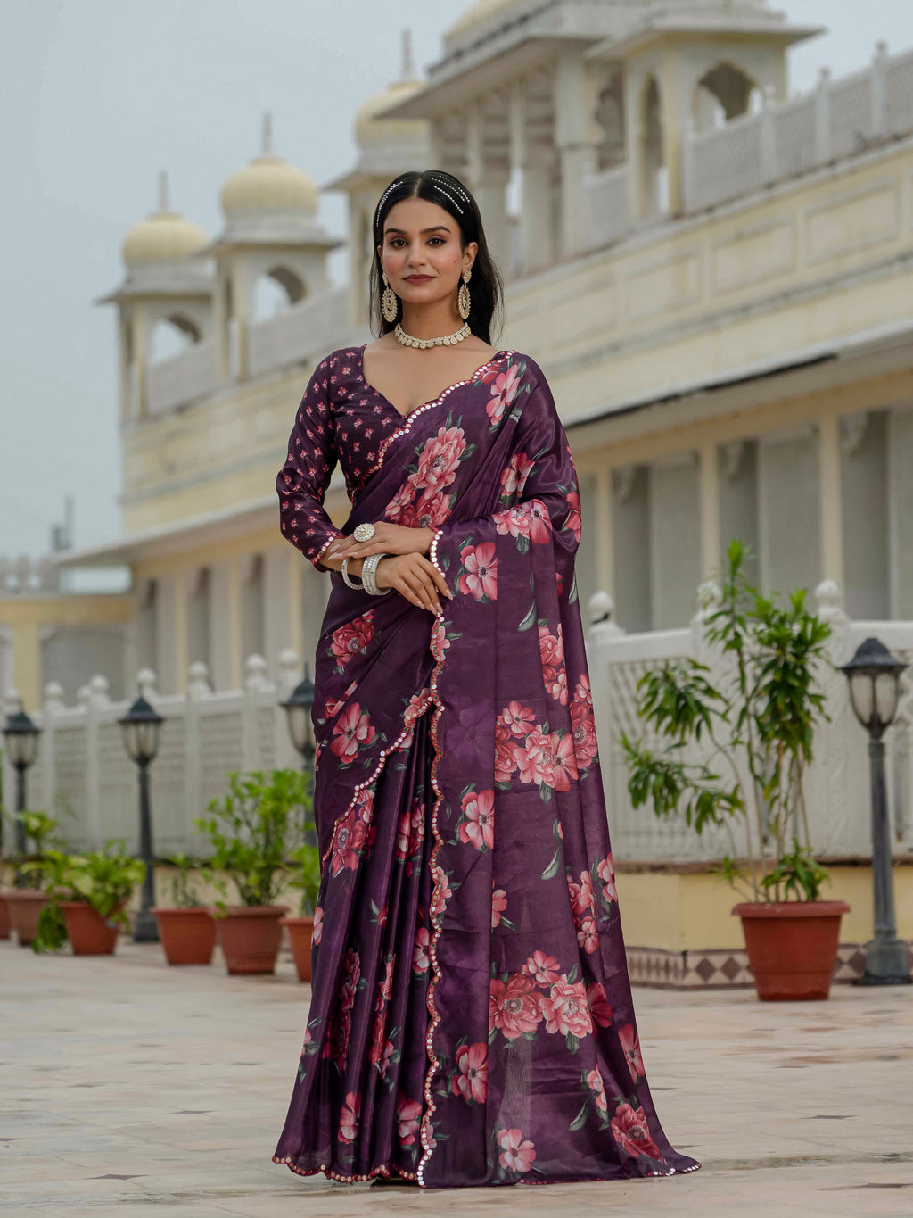 Woman in a purple ready to wear saree standing in front of a building with architectural details.