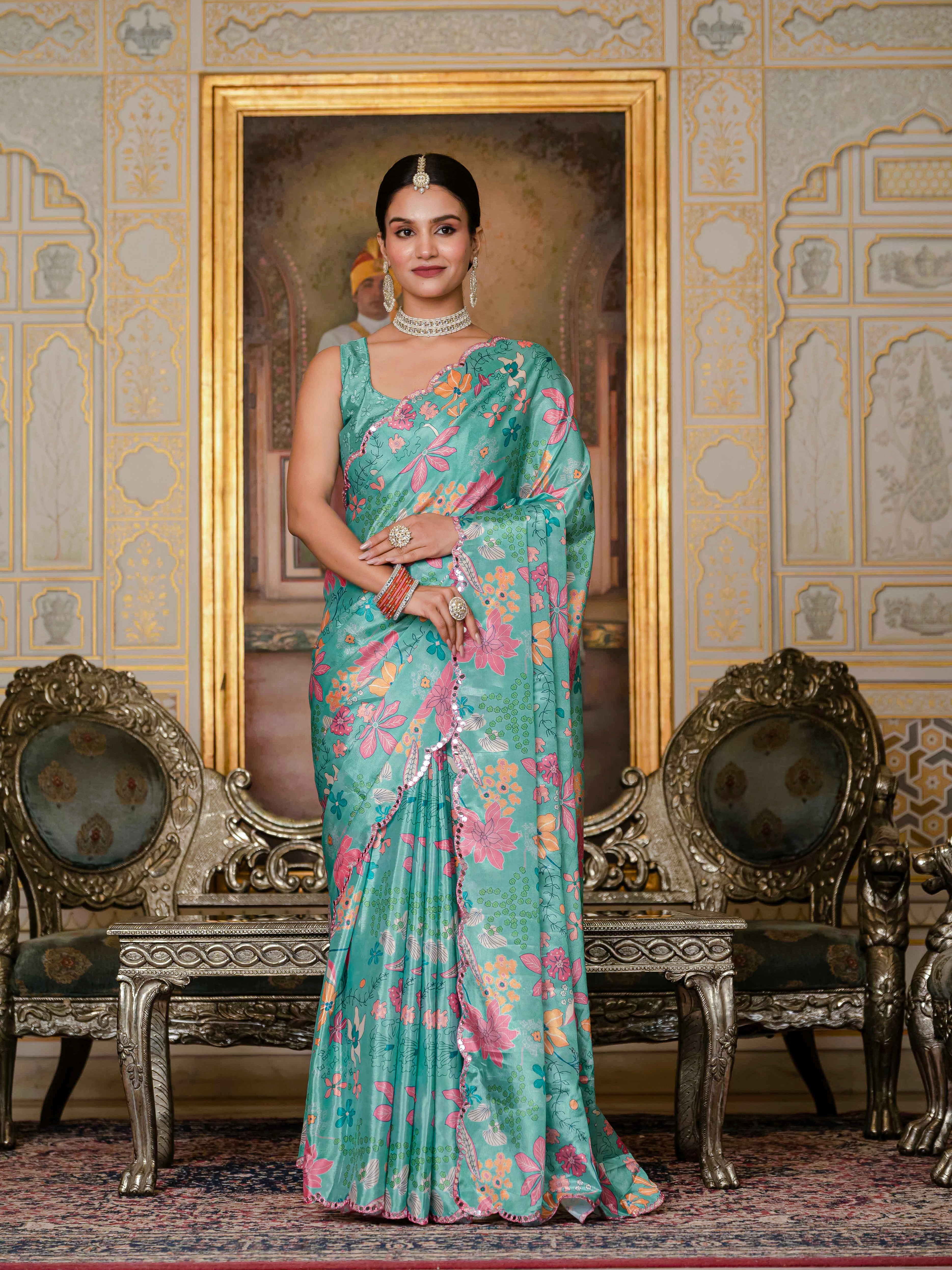 Woman in a Green ready to wear saree with floral patterns standing in an ornate room.