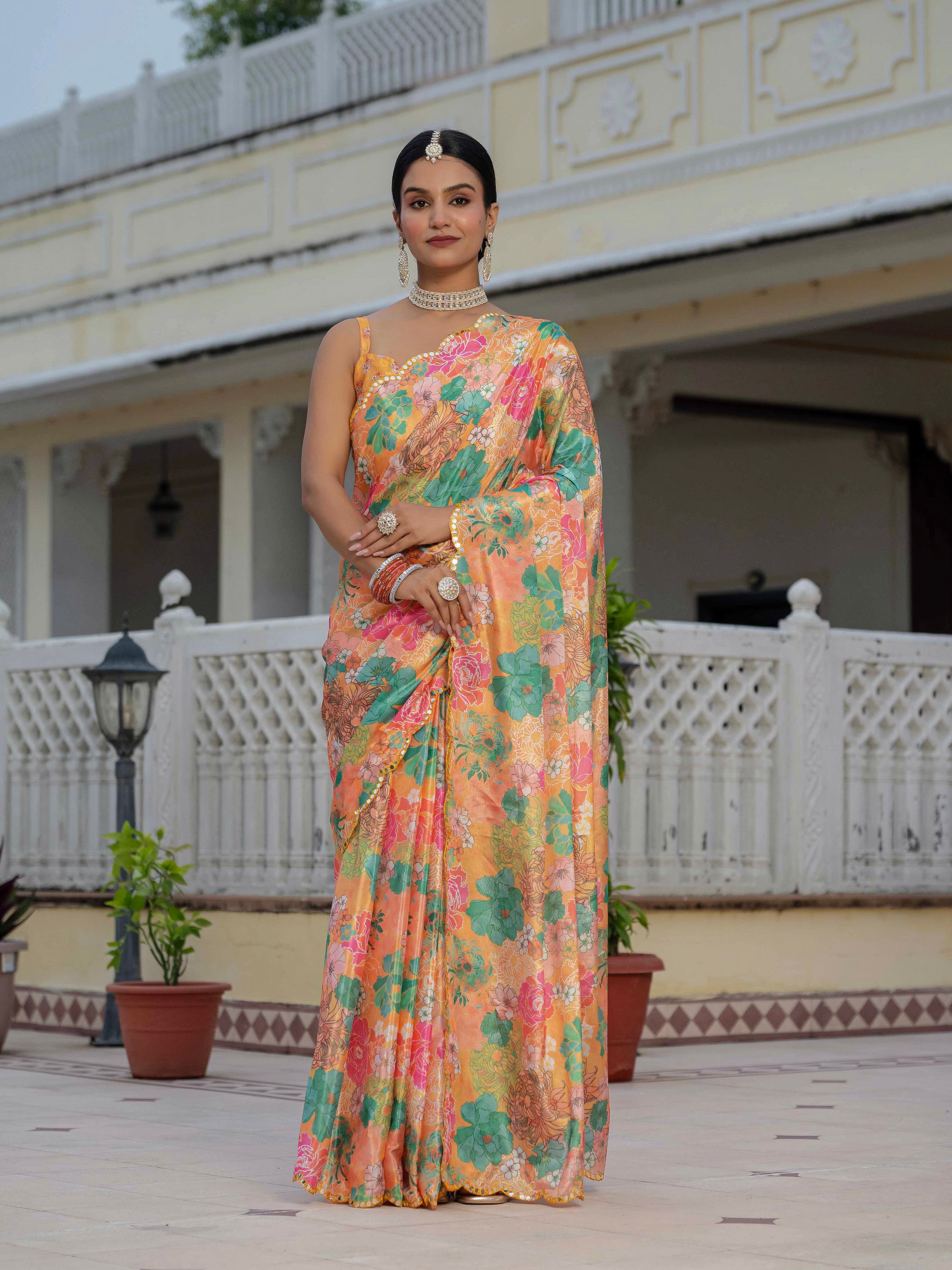 Woman in a ready to wear saree standing in front of a white building with decorative columns.