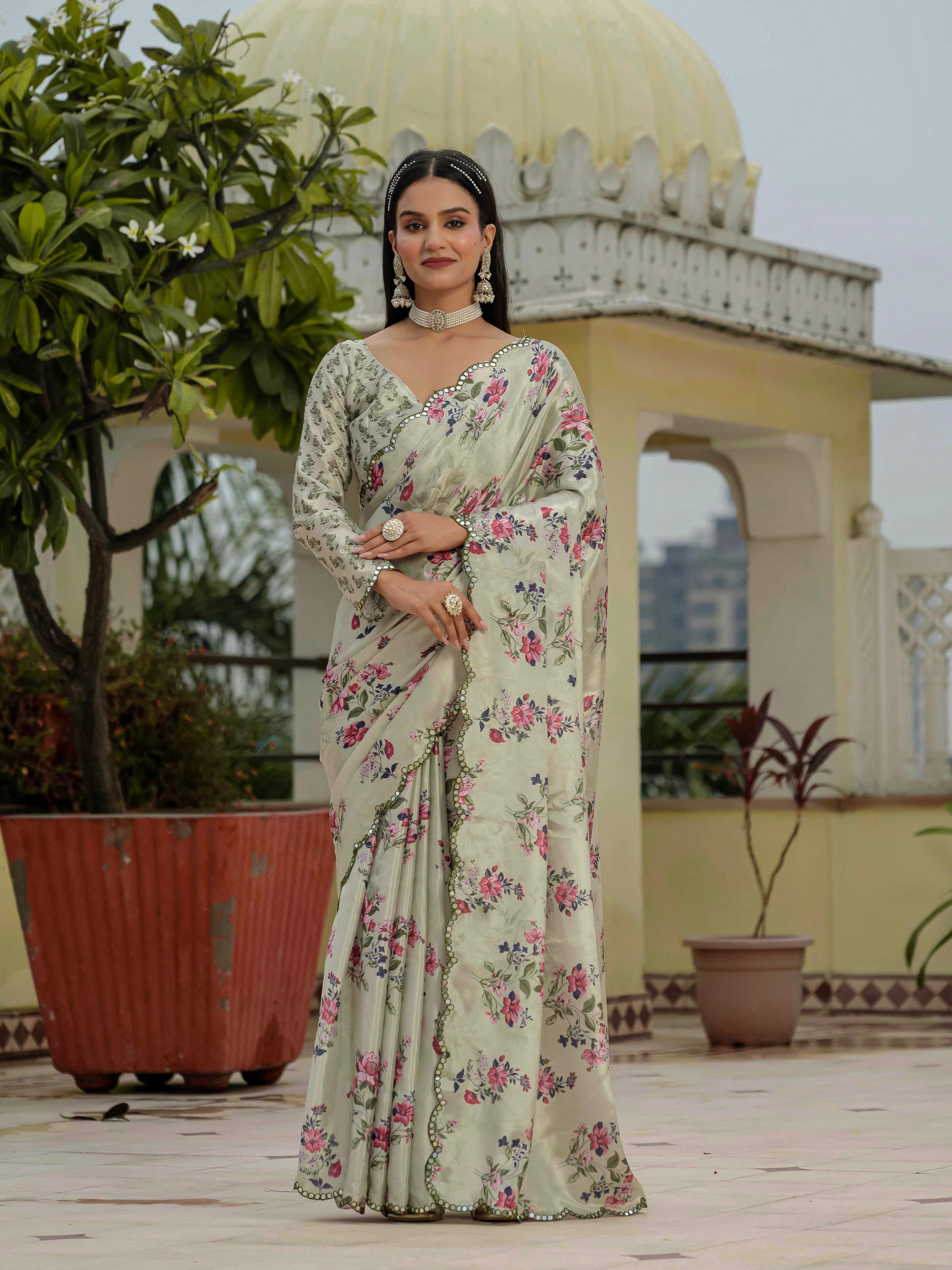 Woman in a ready to wear saree standing on a rooftop with architectural elements and plants in the background