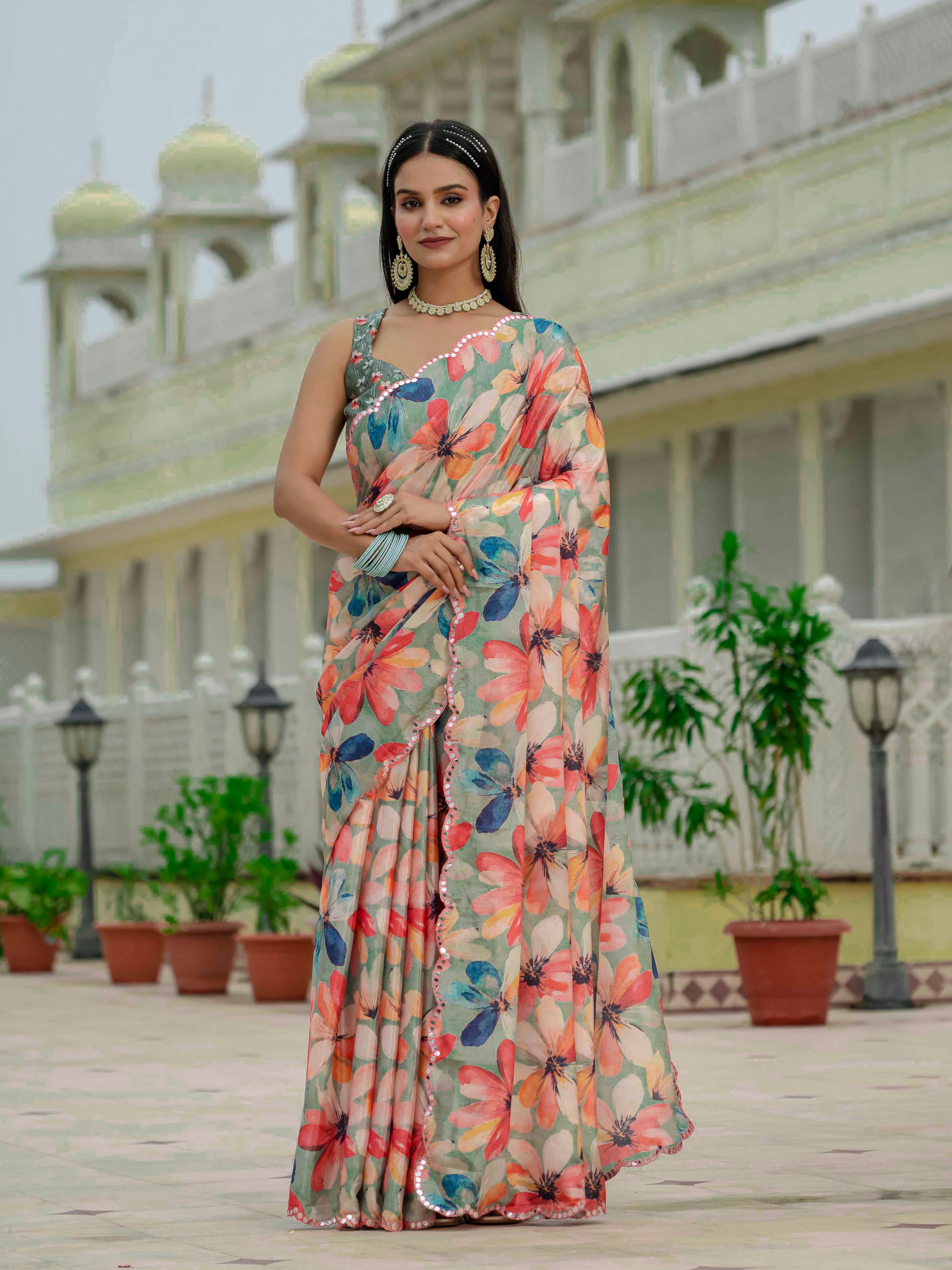 Woman in a ready to wear saree standing in front of a building with architectural elements.