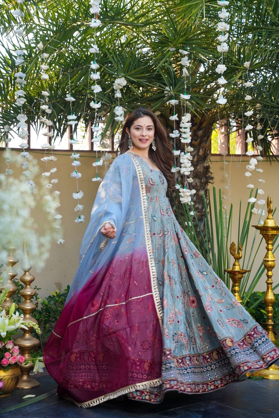 Woman in a Anarkali Gown outfit with a floral and decorative background