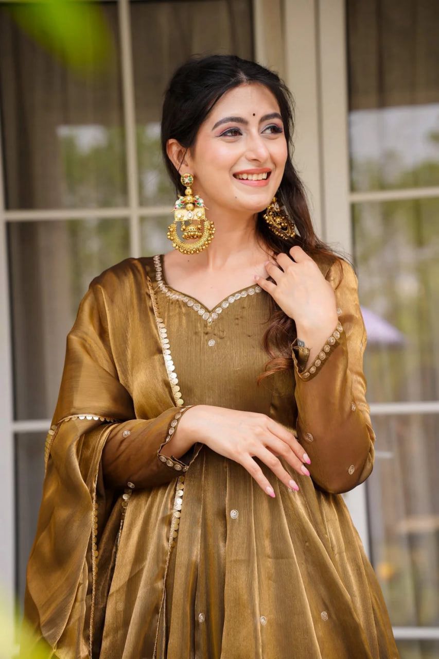 A Woman in Anarkali gown or dress attire with gold jewellery outdoors
