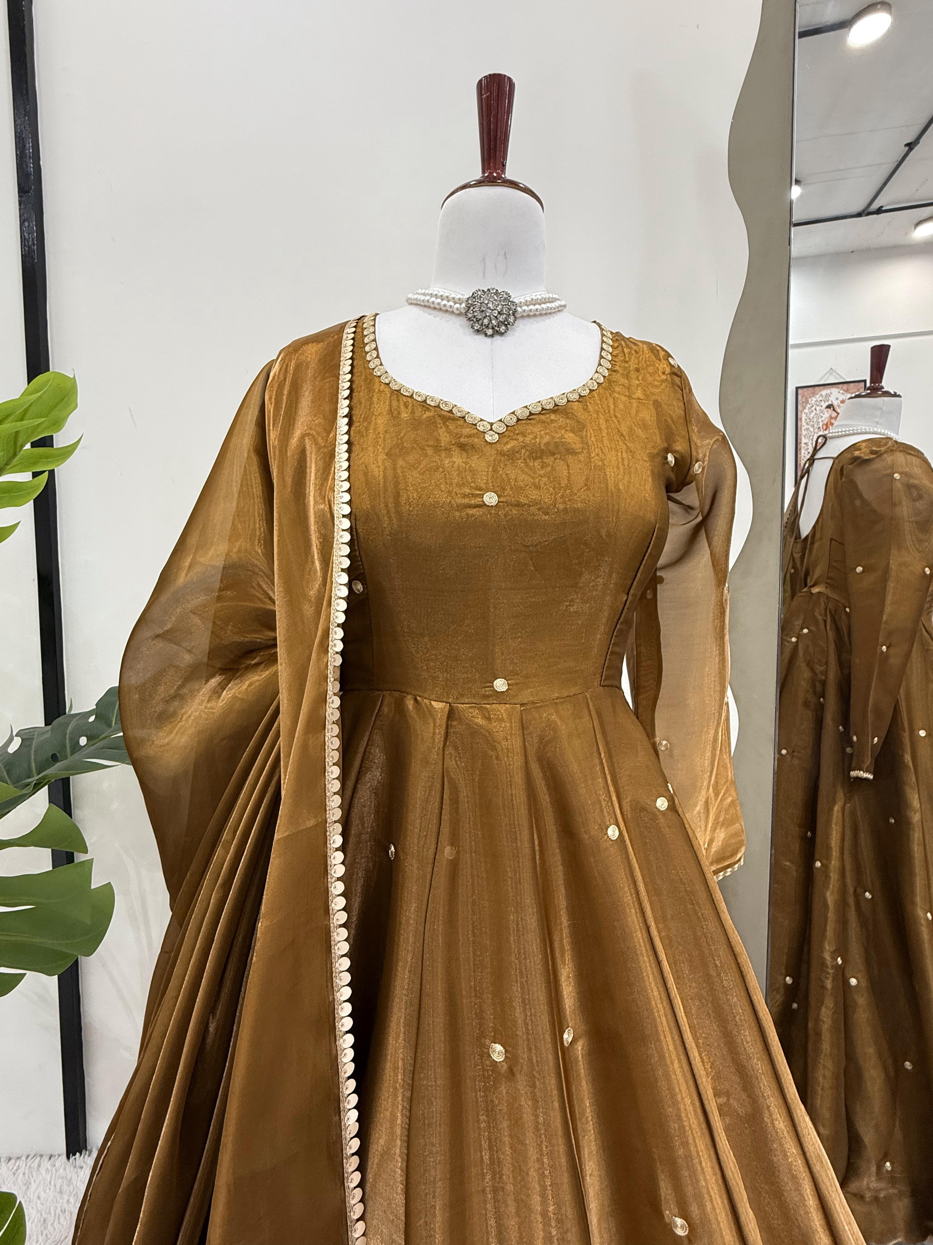 Brown velvet Anarkali gown or dress with sheer sleeves on a mannequin against a white background