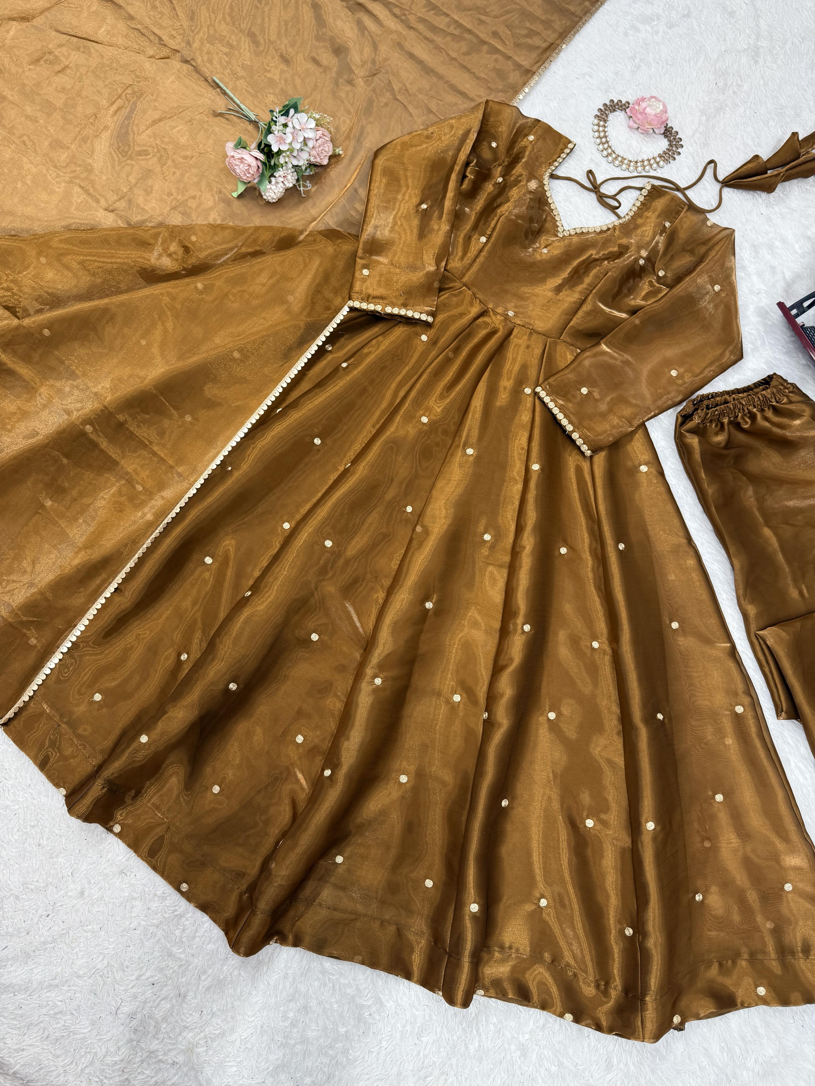 Brown Anarkali gown or dress with embellishments on a white surface