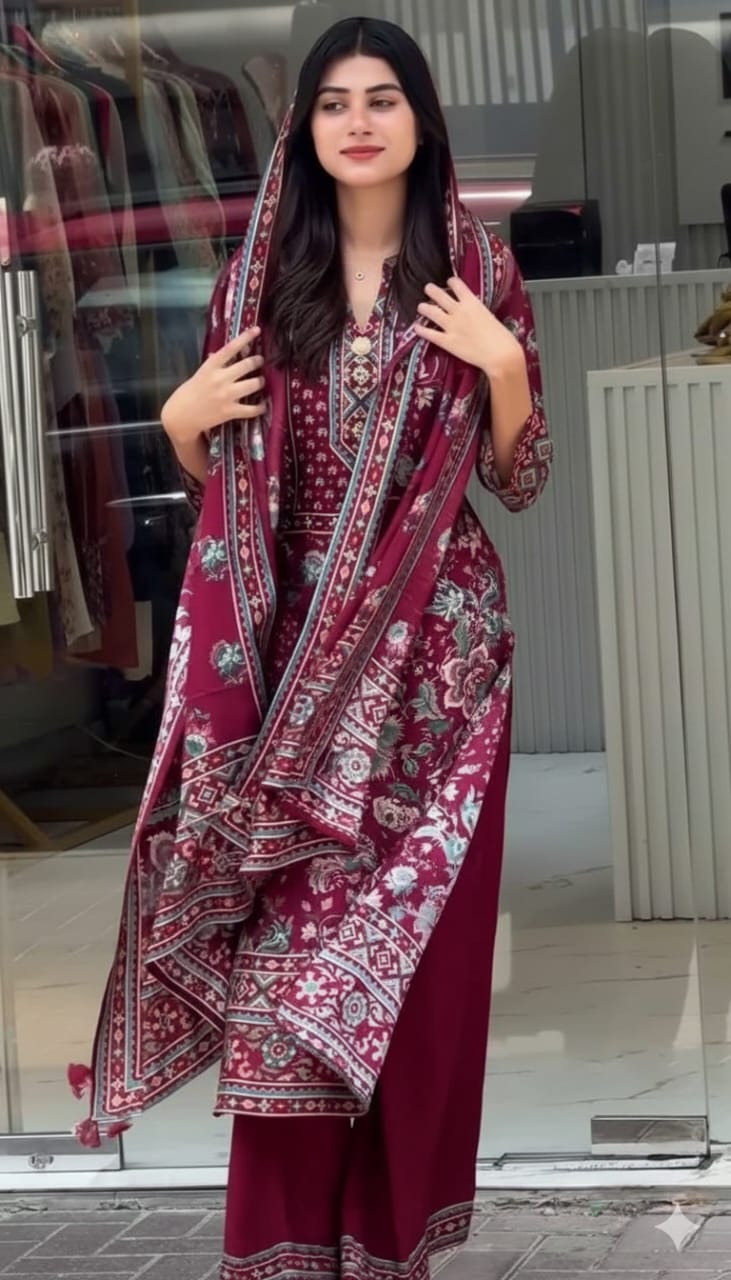 A woman wearing a maroon kurta set dress outfit with a patterned dupatta in an urban setting.