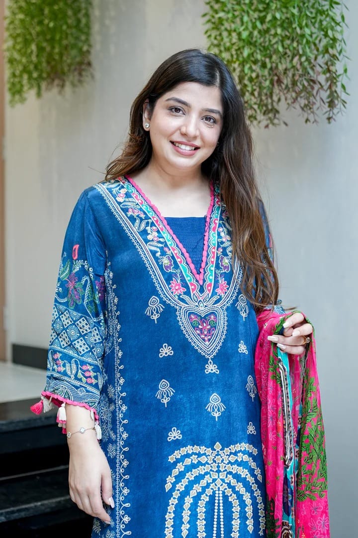 Woman wearing a blue digital printed traditional outfit with a pink and green dupatta.