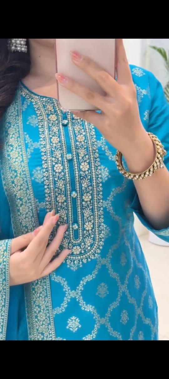 A person wearing a blue kurta set traditional outfit, taking a mirror selfie.
