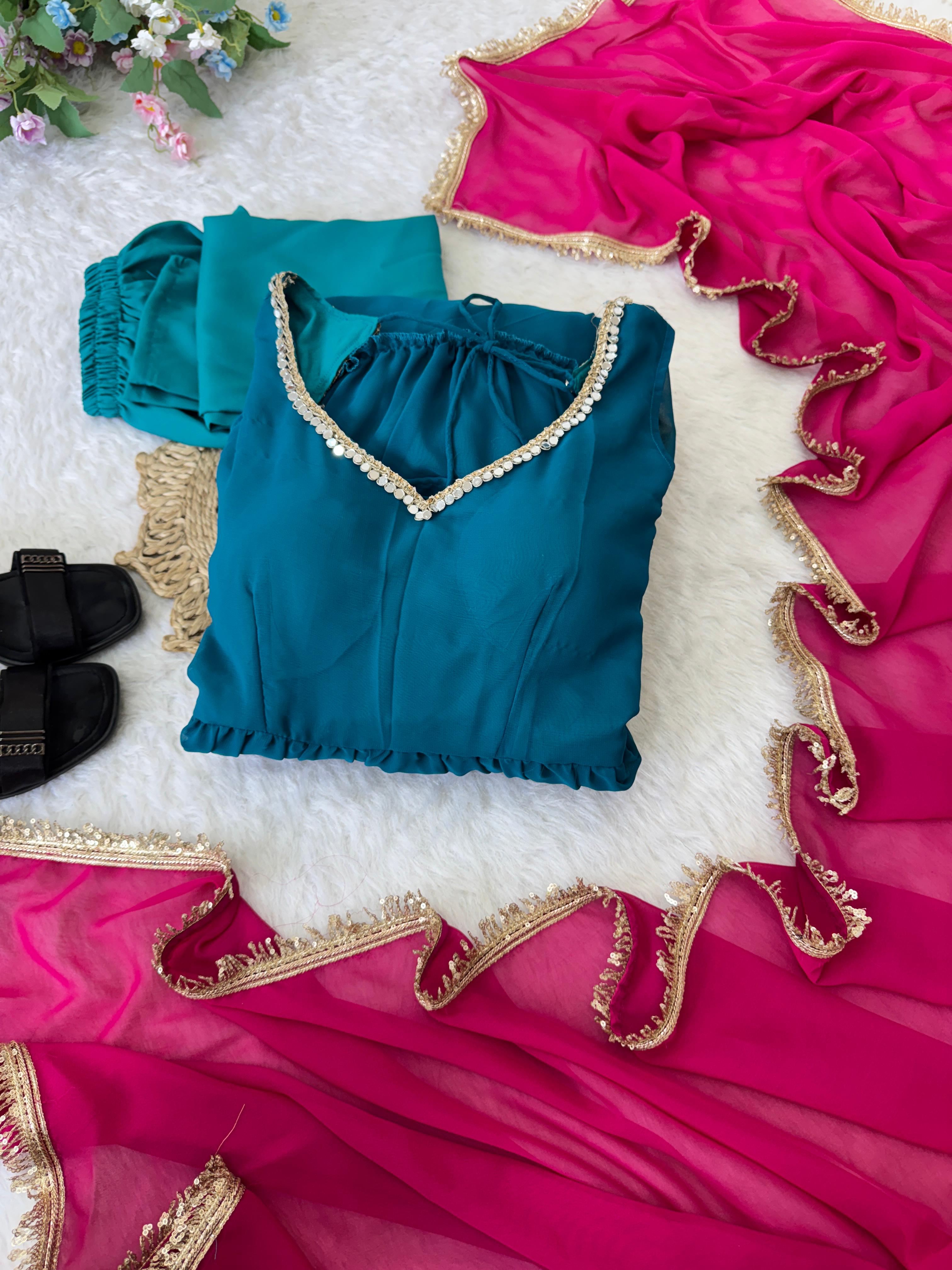 Blue anarkali dress with gold trim on a pink dupatta fabric background