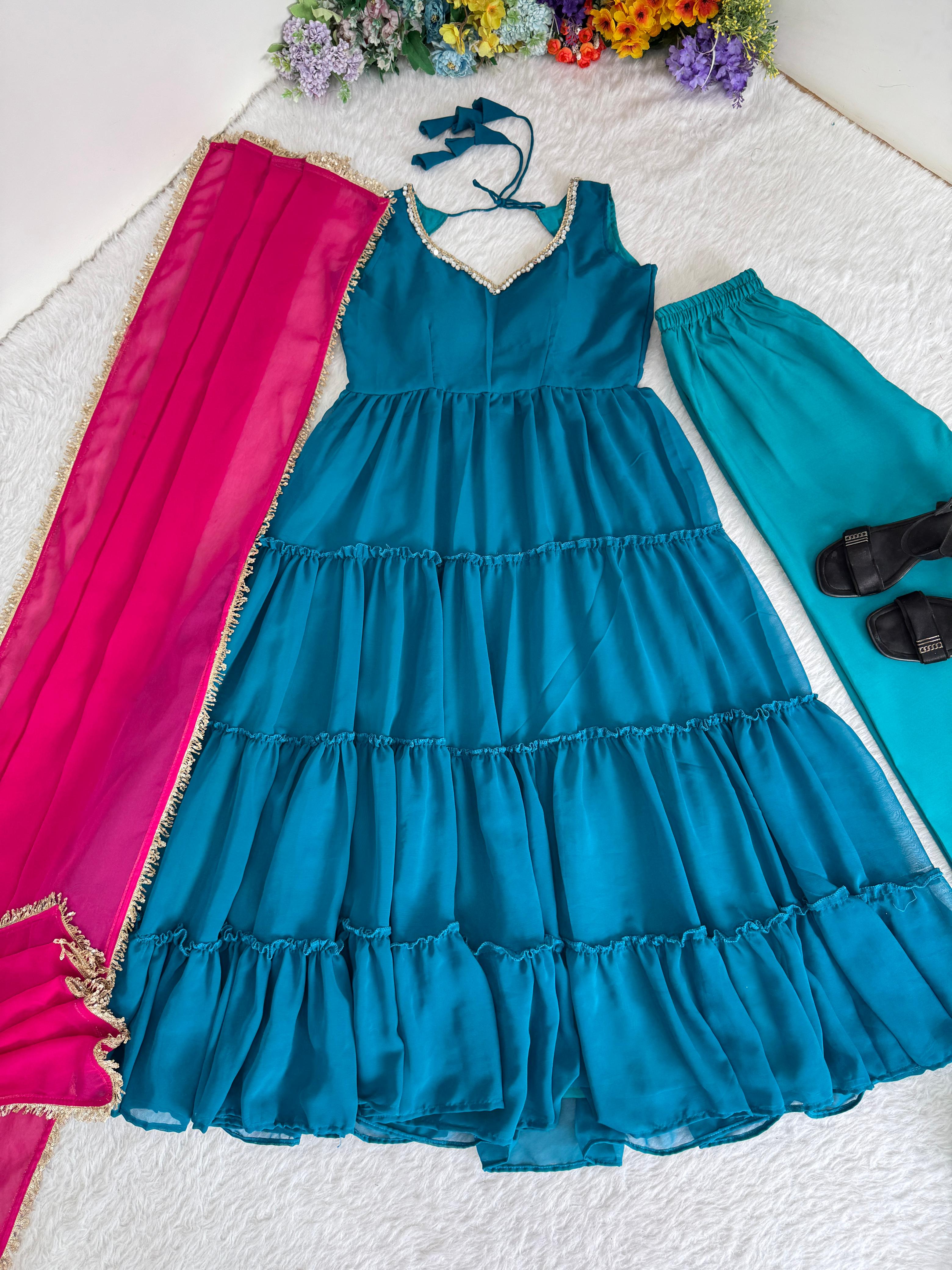 Blue anarkali dress with pink and turquoise pants on a white surface