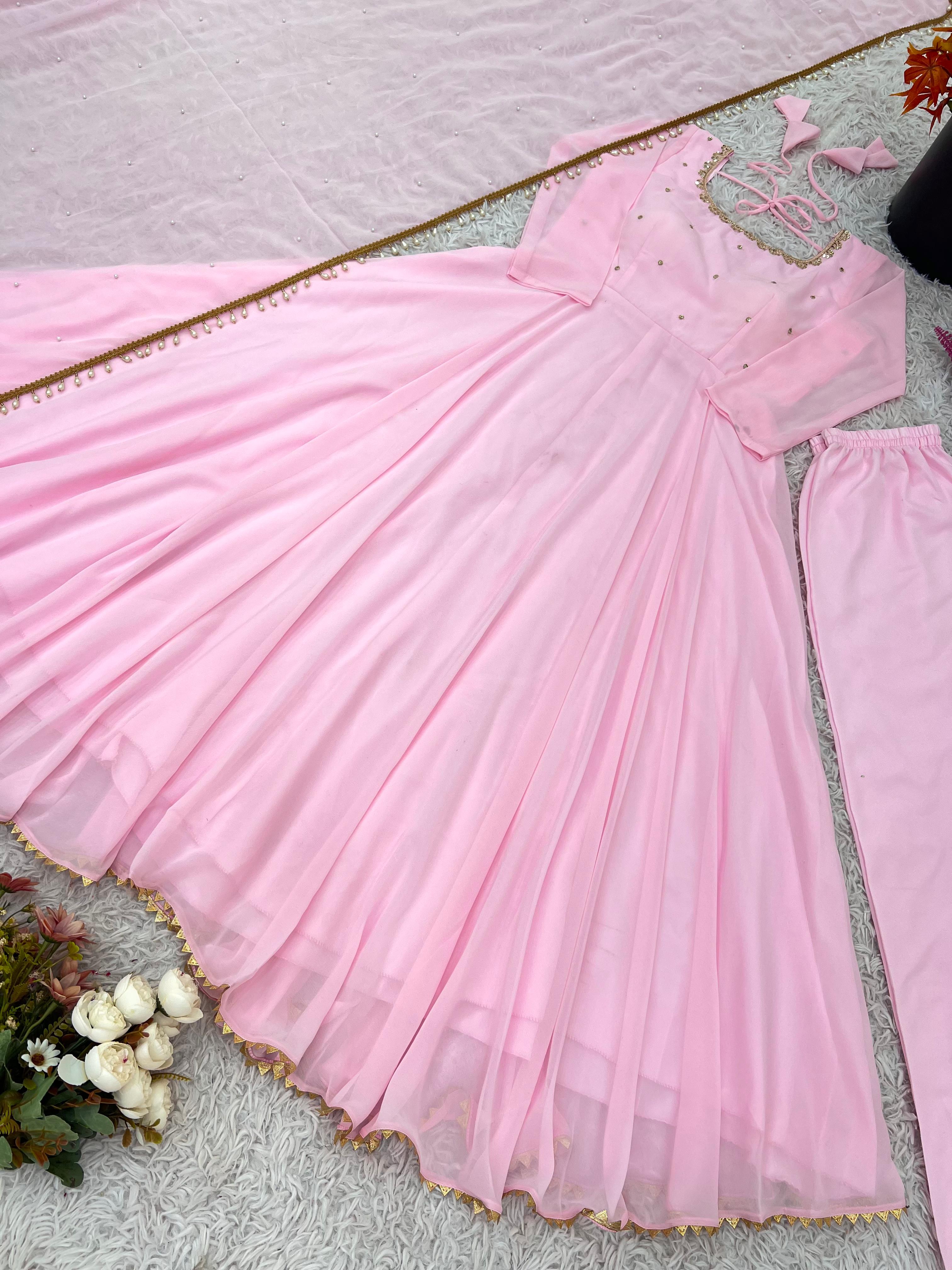 Pink dress on a light gray surface with flowers.