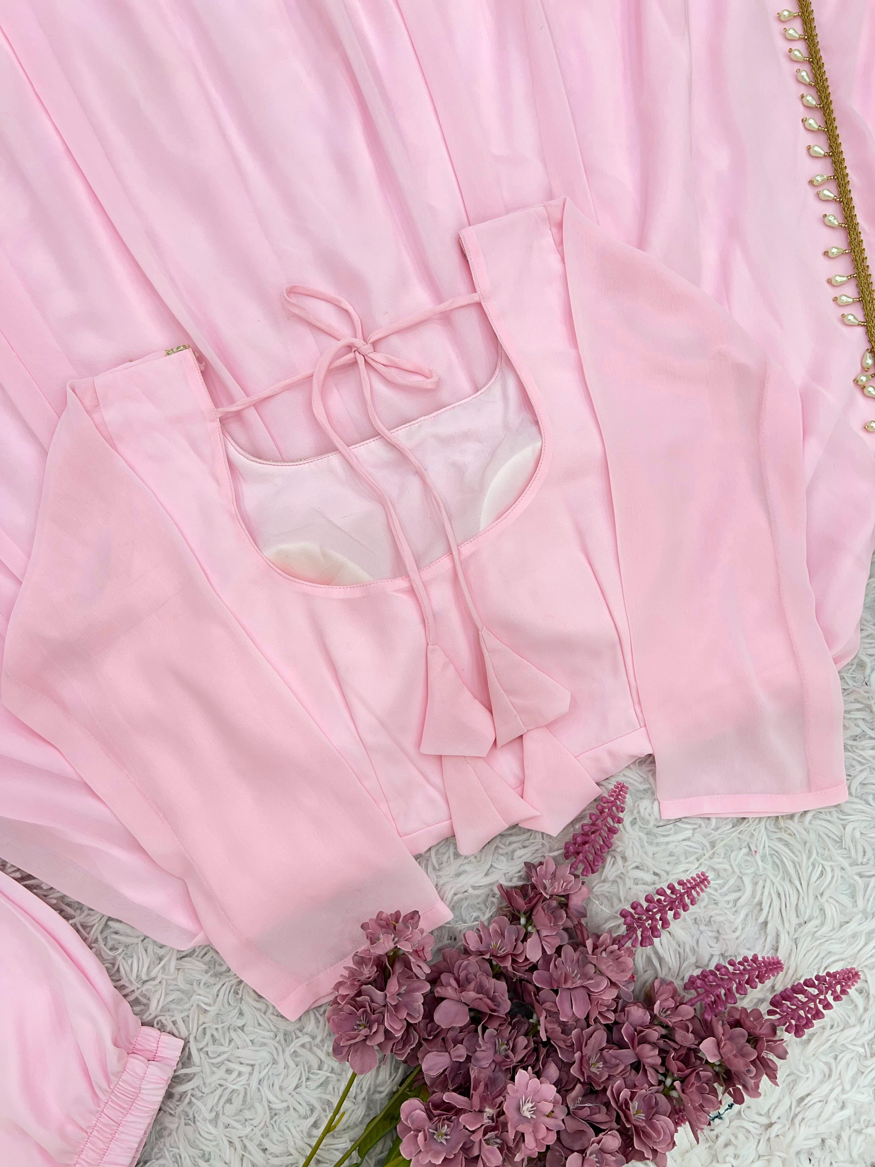 Pink satin robe with a floral arrangement on a textured surface