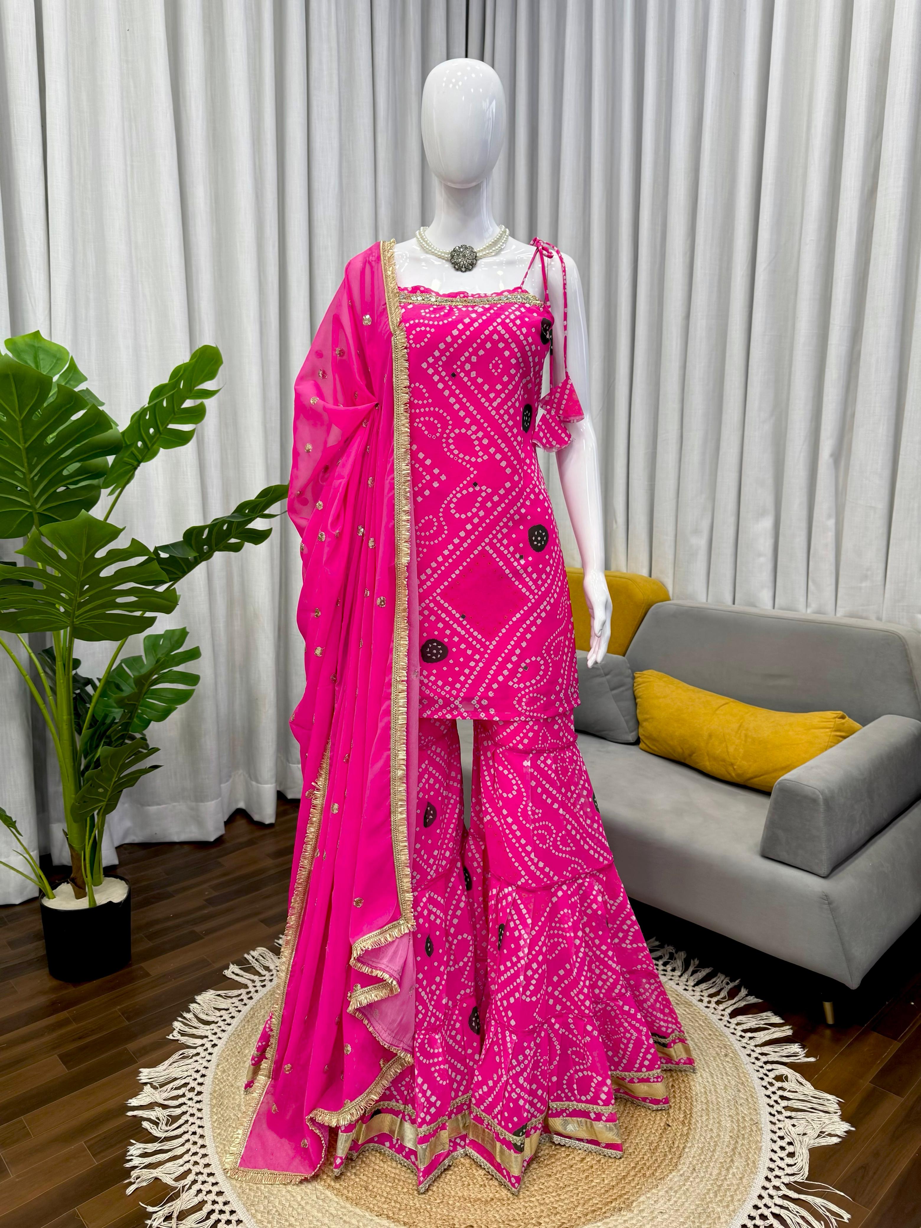 Mannequin wearing a bright pink sharara set traditional outfit with a matching dupatta in a living room setting.