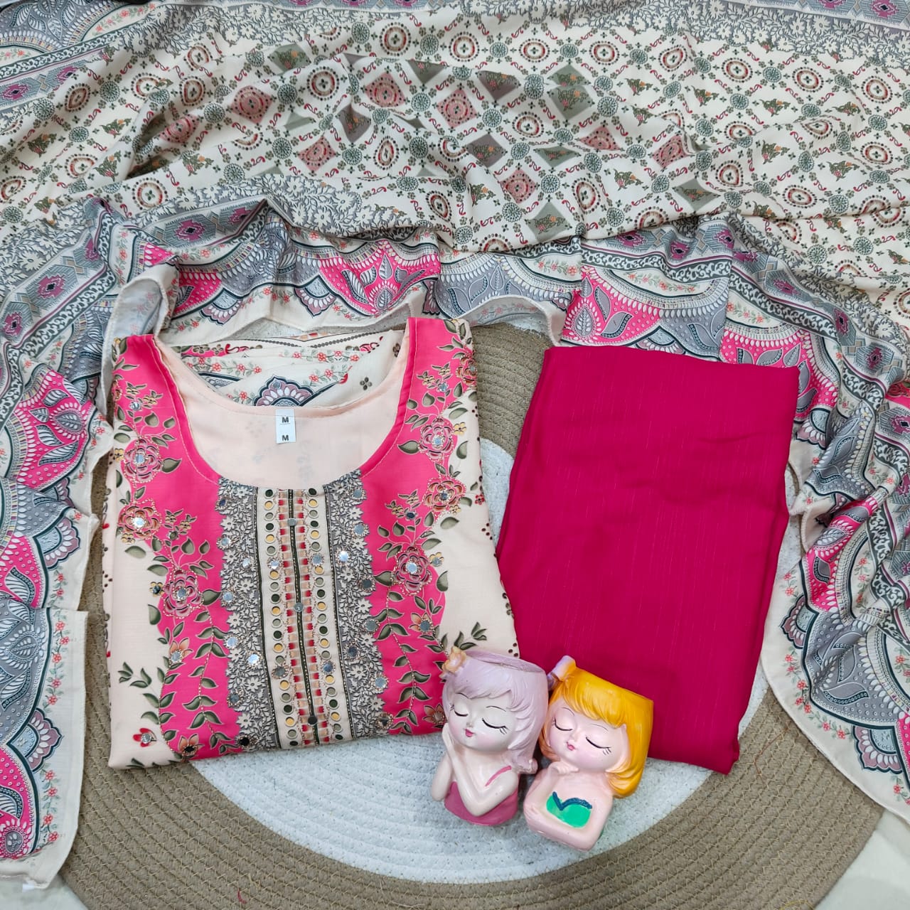 Pink and white top with pink pants on a patterned fabric background