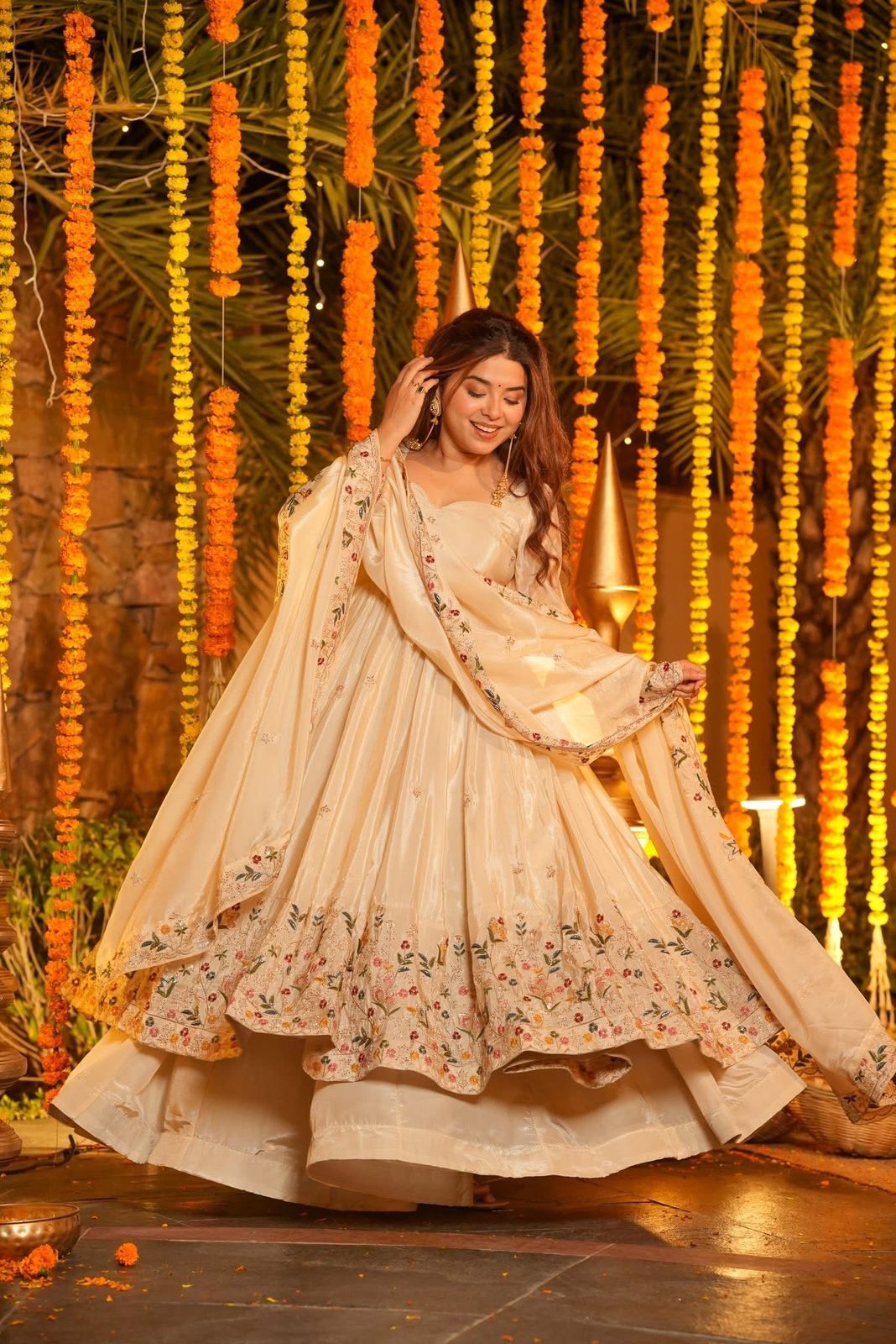 Woman in a traditional outfit with floral patterns against a decorative background