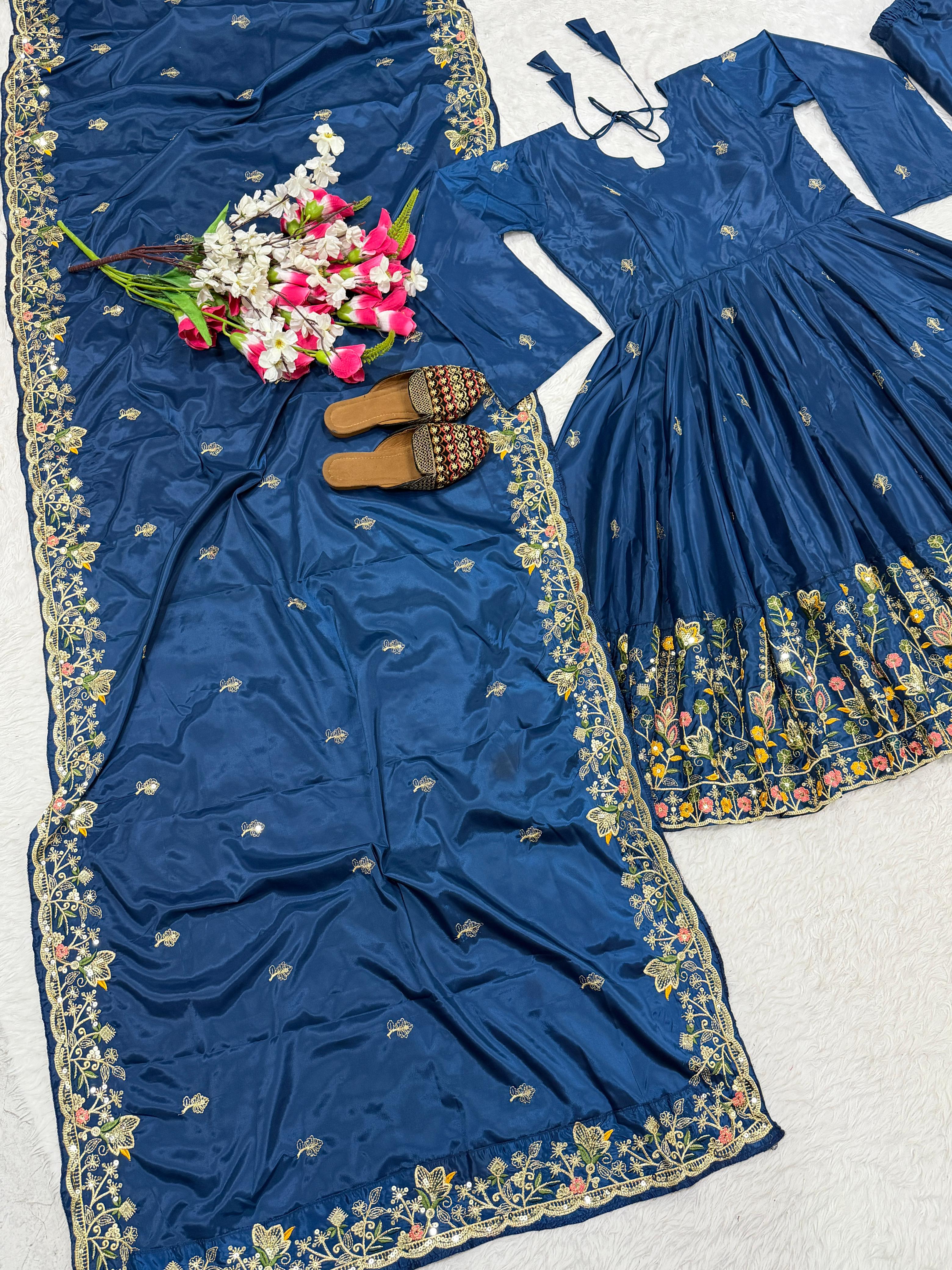 Blue embroidered dress with floral patterns on a light gray background