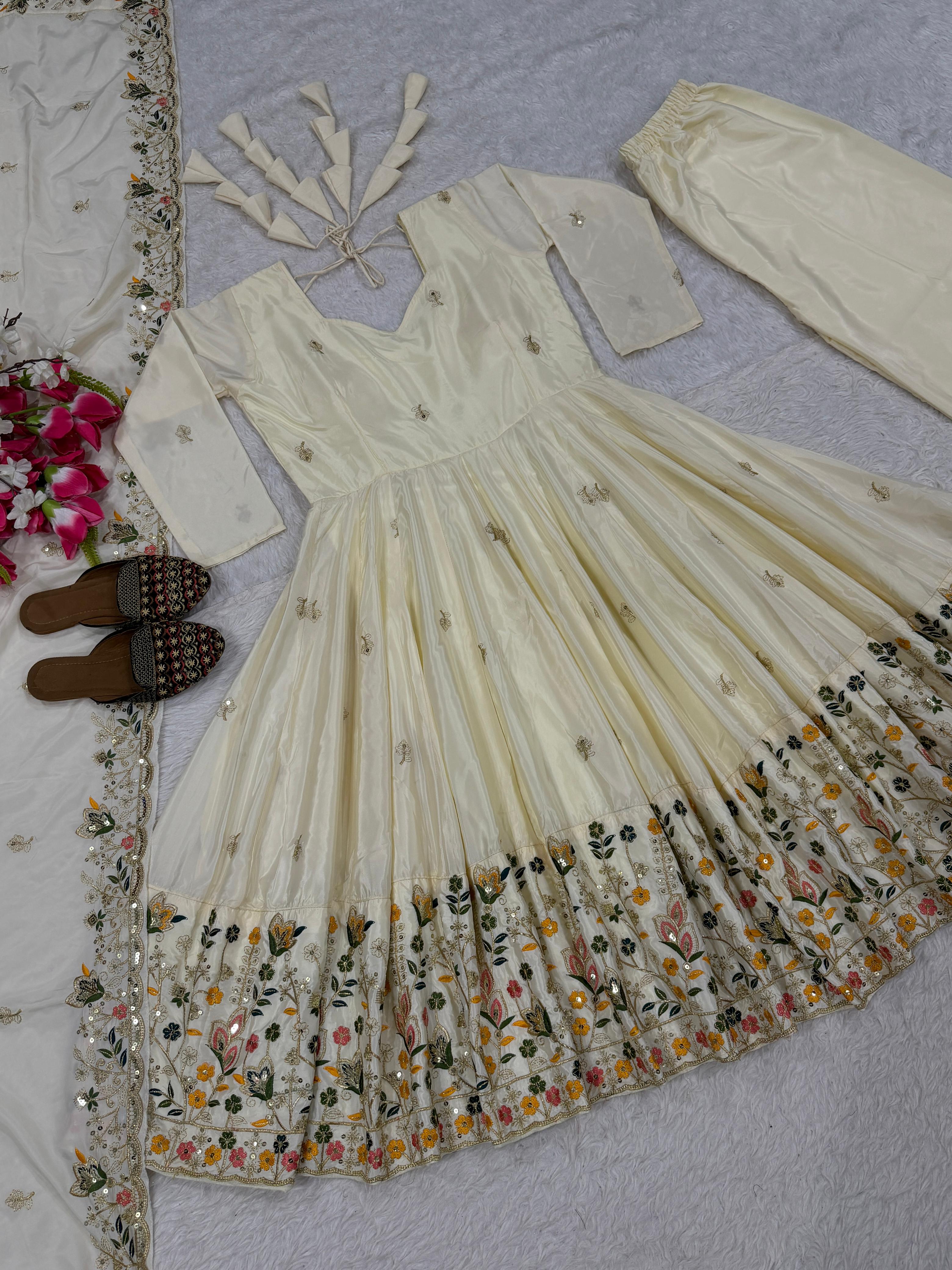White embroidered traditional outfit with floral patterns on a light blue fabric background.