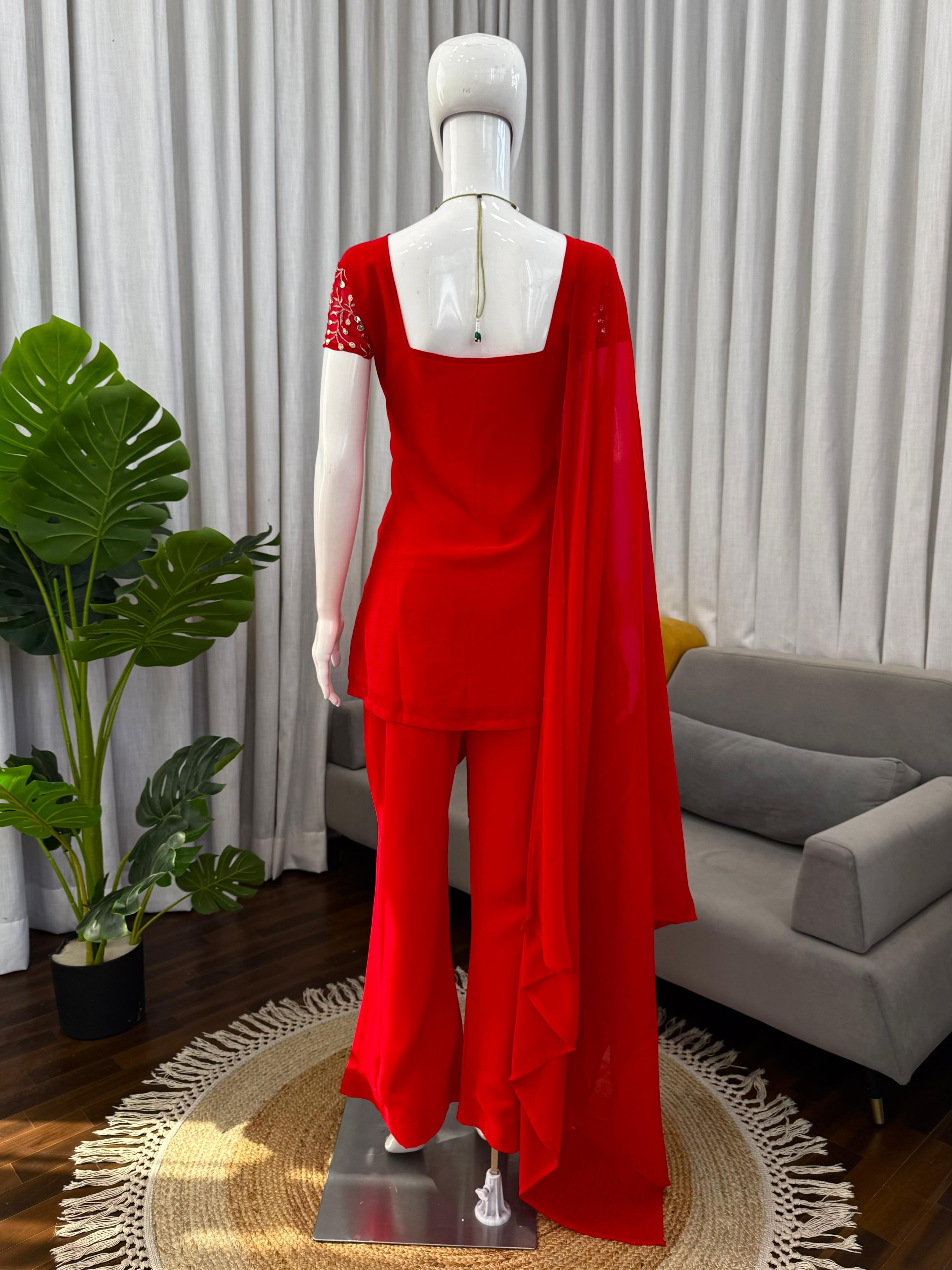 Red outfit on a mannequin in a living room setting with a gray sofa and plant.