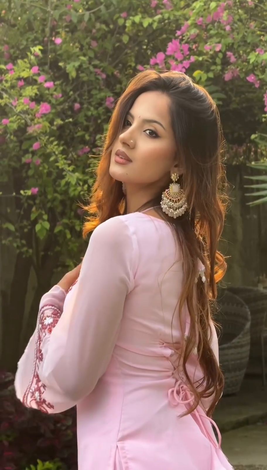 Woman in a pink traditional outfit with floral background