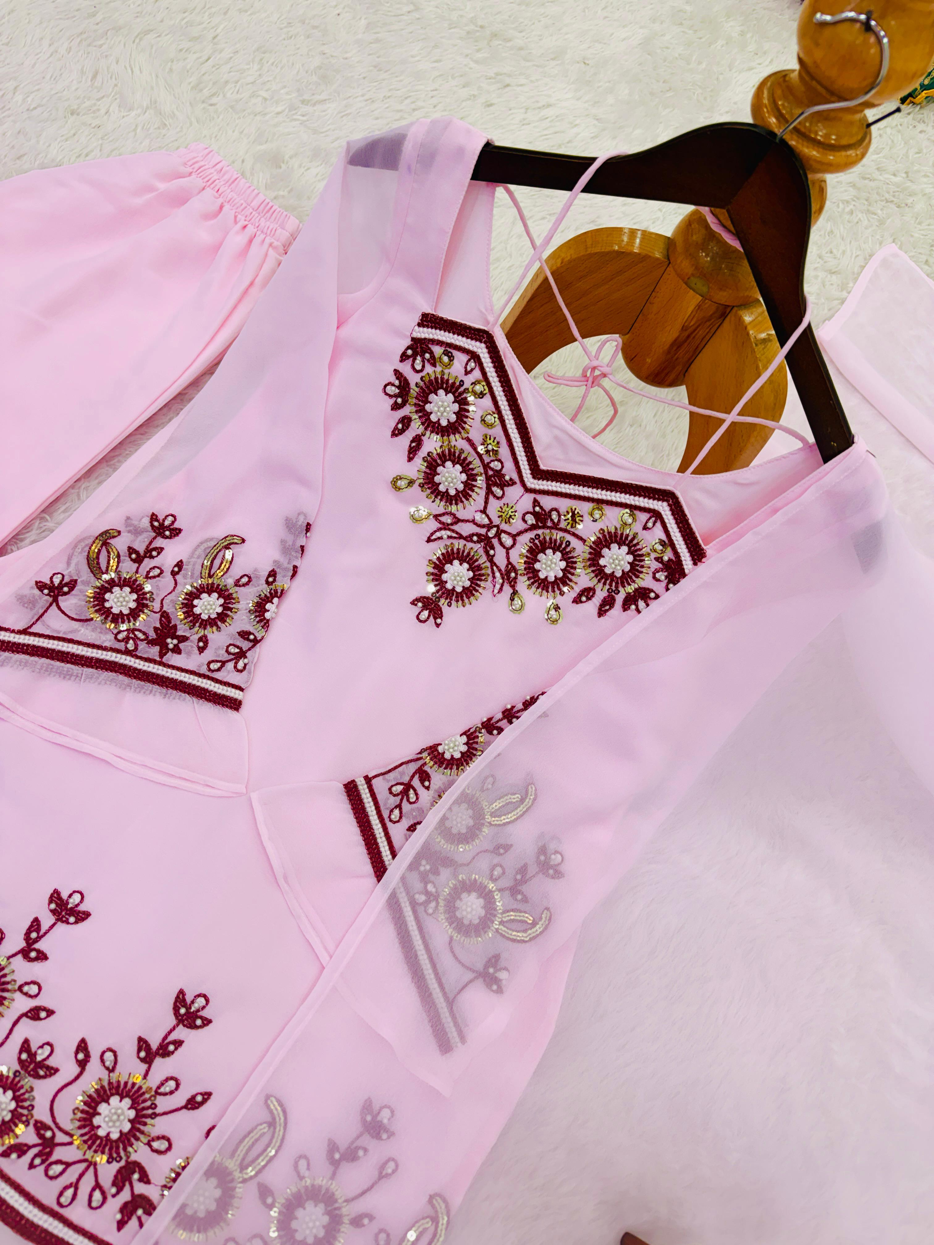 Embroidered pink fabric with floral patterns on a light background