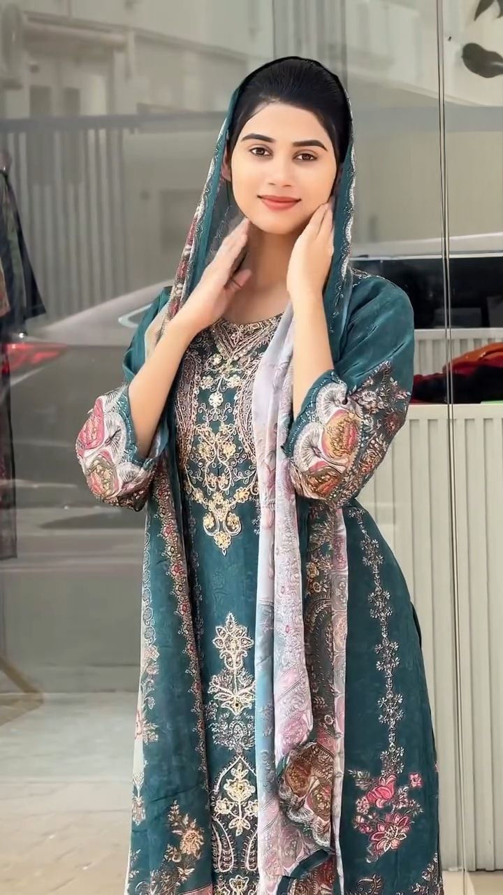 Woman wearing a traditional embroidered outfit with a floral pattern.