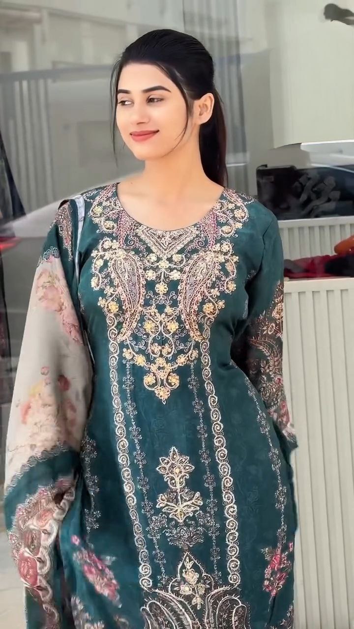Woman wearing a green digital printed traditional outfit indoors.