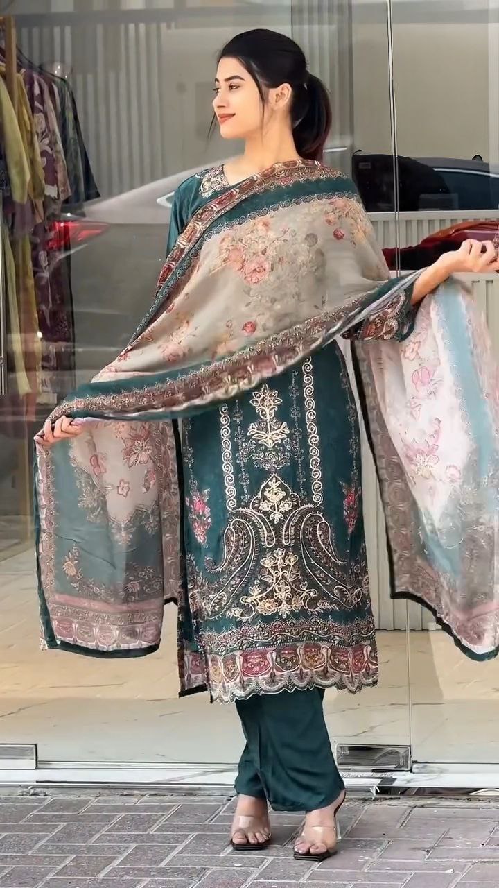 Woman holding a traditional embroidered dupatta in an indoor setting