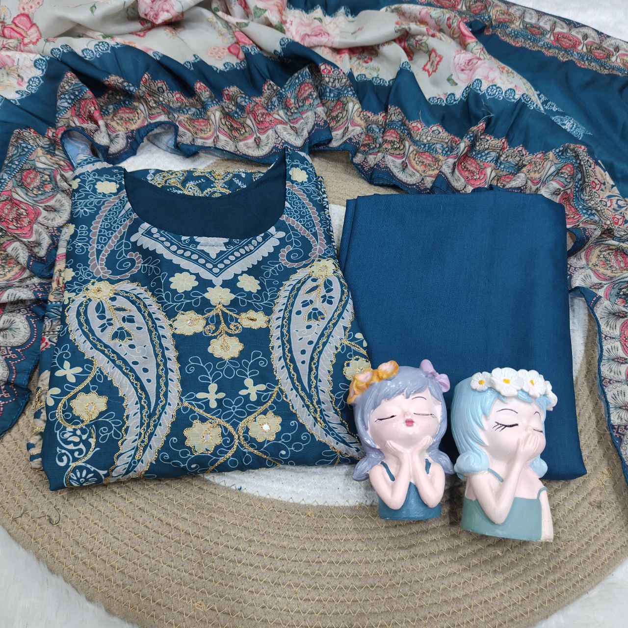 Decorative pillows with floral patterns and two small figurines on a textured surface.