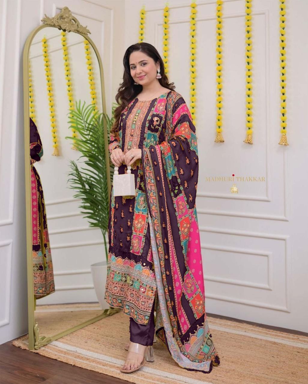 Woman in a colorful traditional outfit standing in front of a mirror.